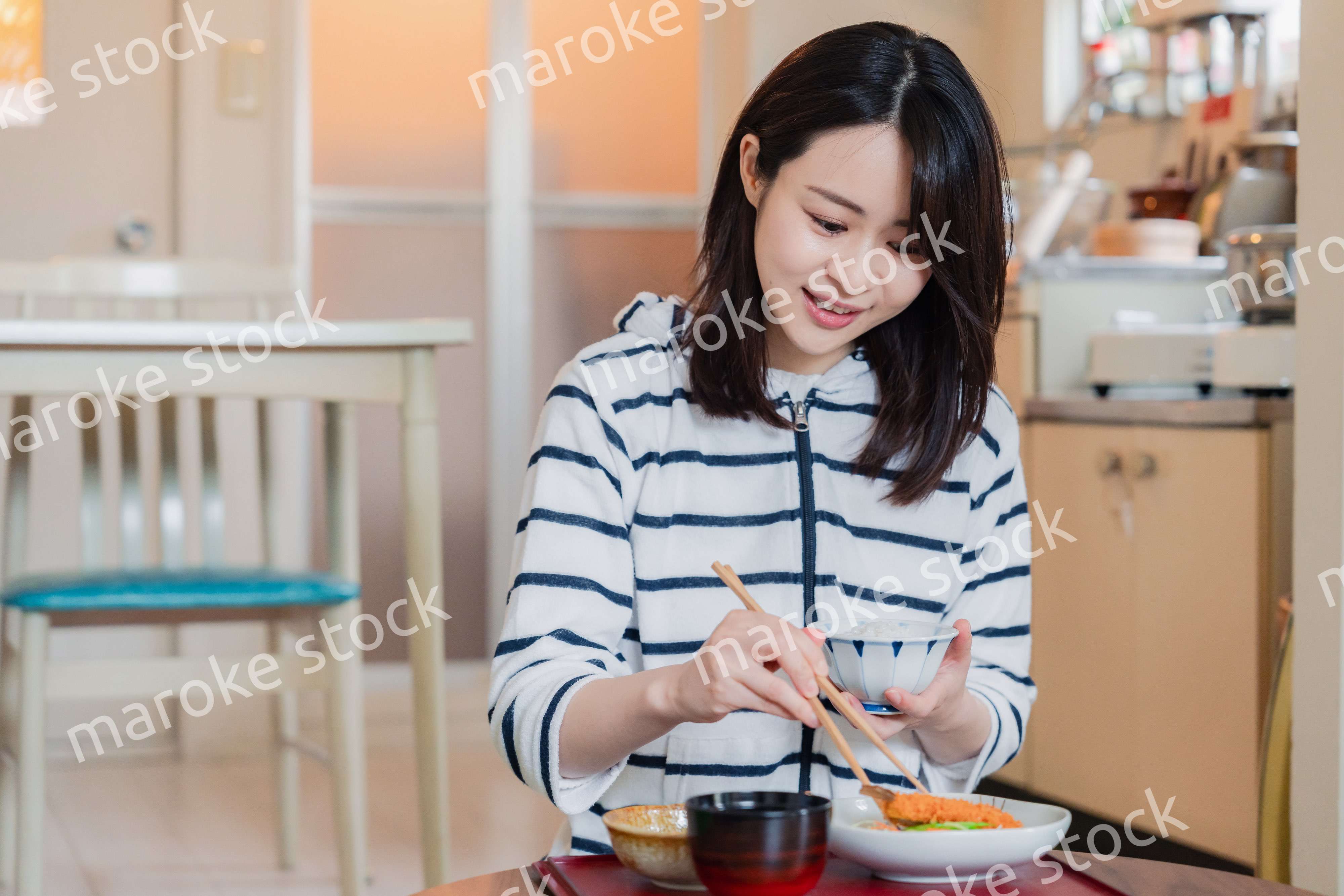 質素な家でごはんを食べる一人暮らしの女性