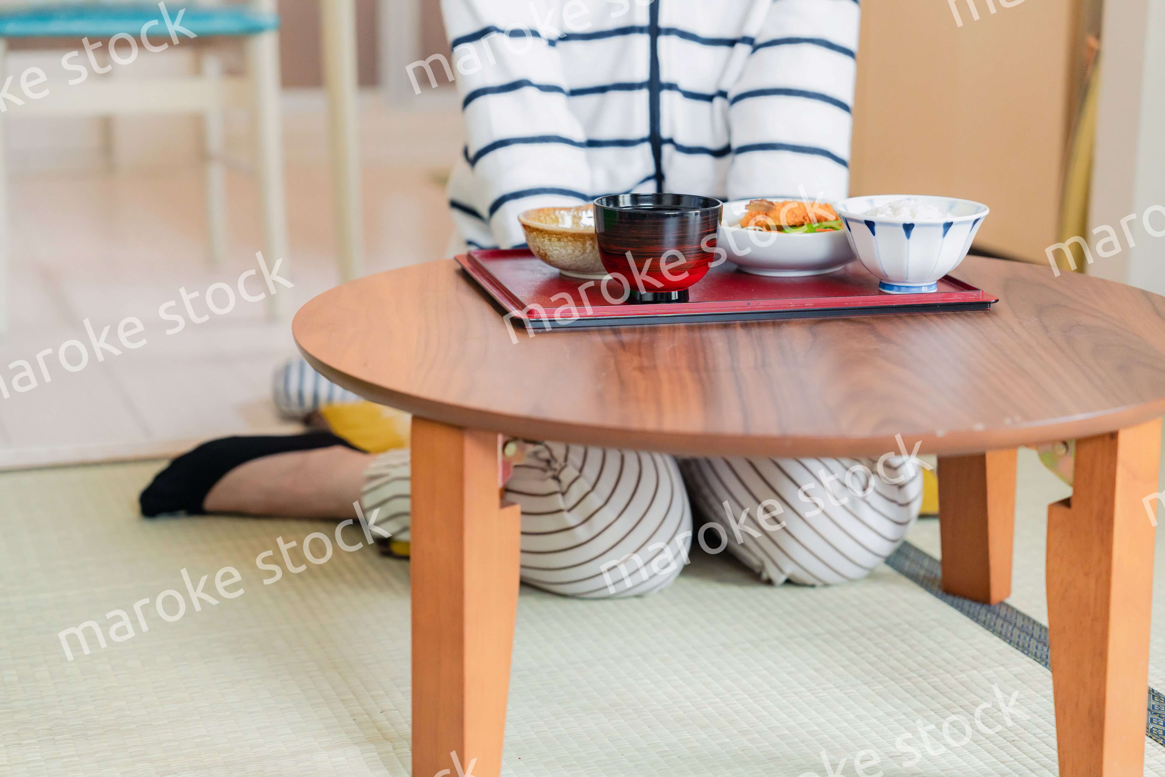 質素な家でごはんを食べる一人暮らしの女性