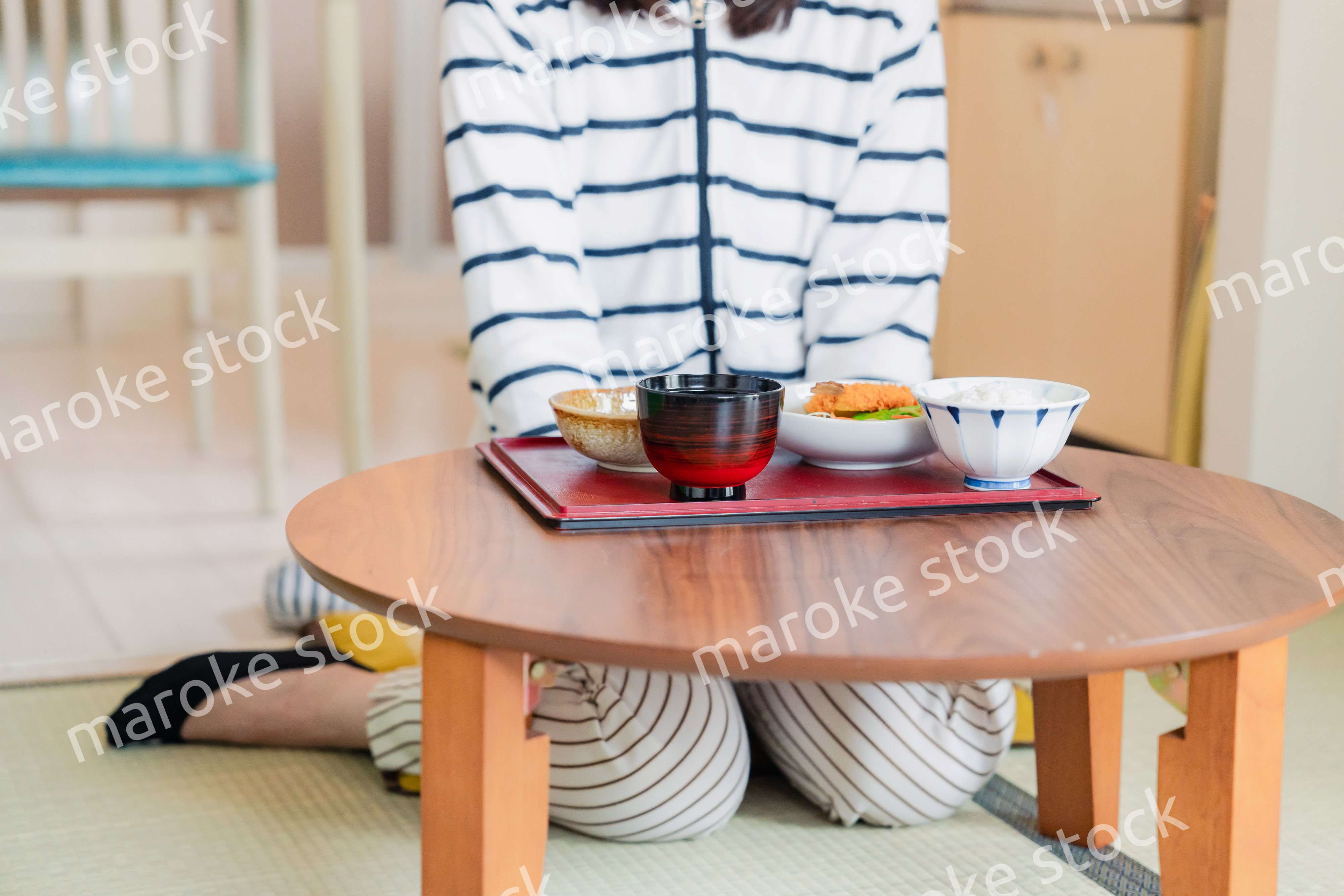 質素な家でごはんを食べる一人暮らしの女性