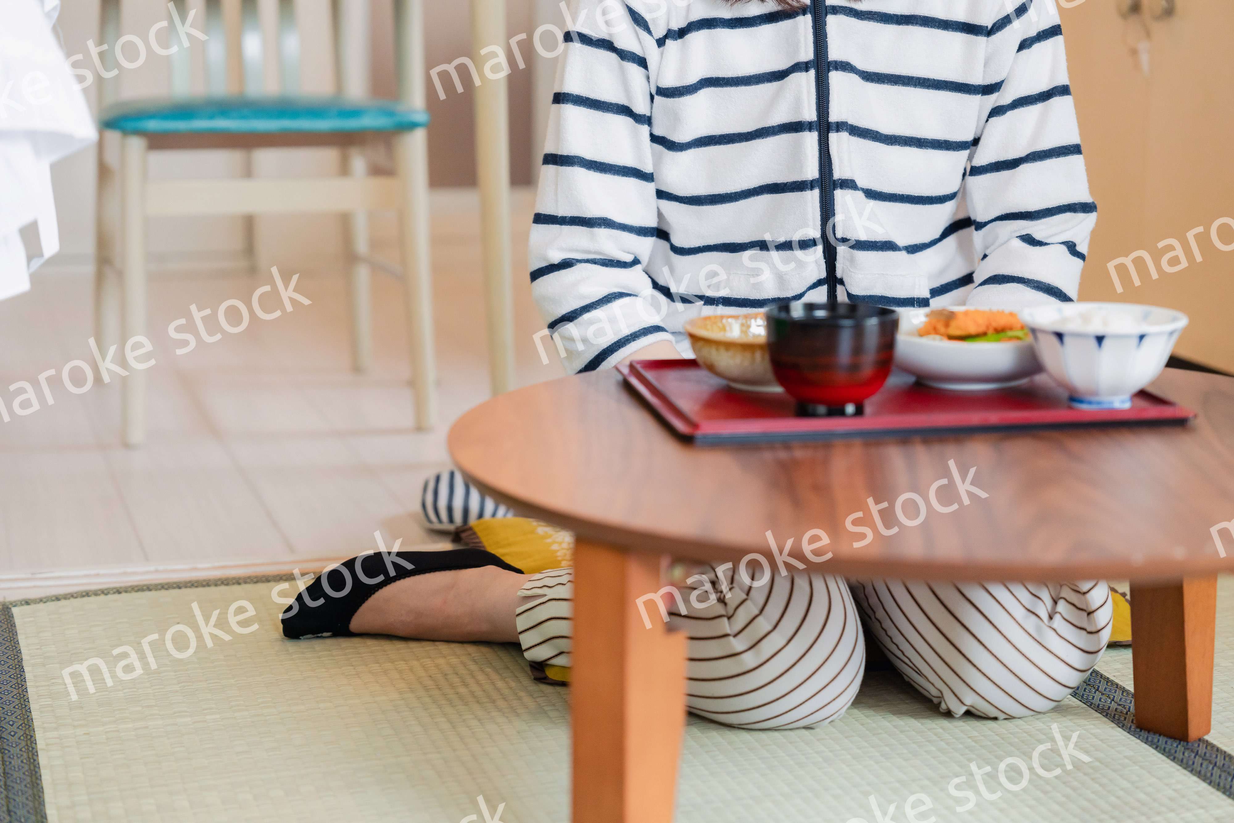 質素な家でごはんを食べる一人暮らしの女性