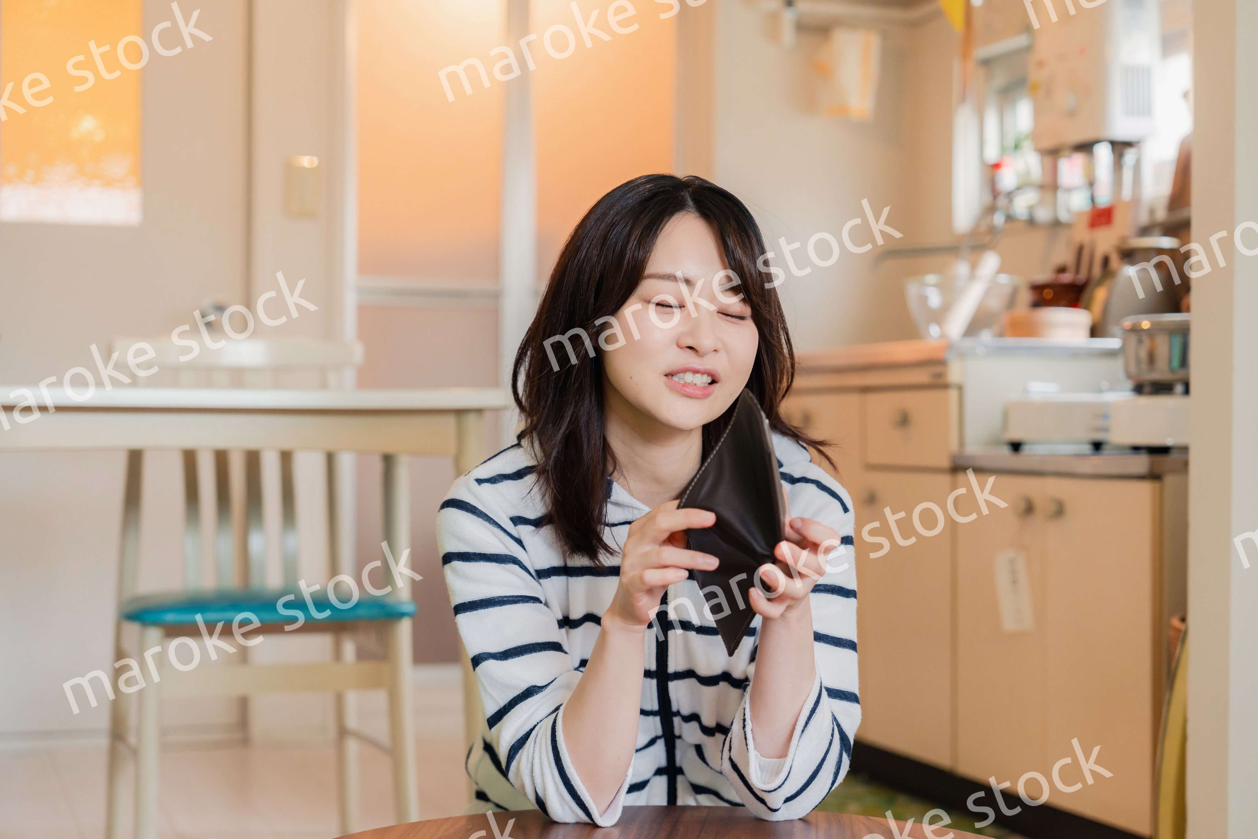 財布の中を確認して落ち込む若い女性