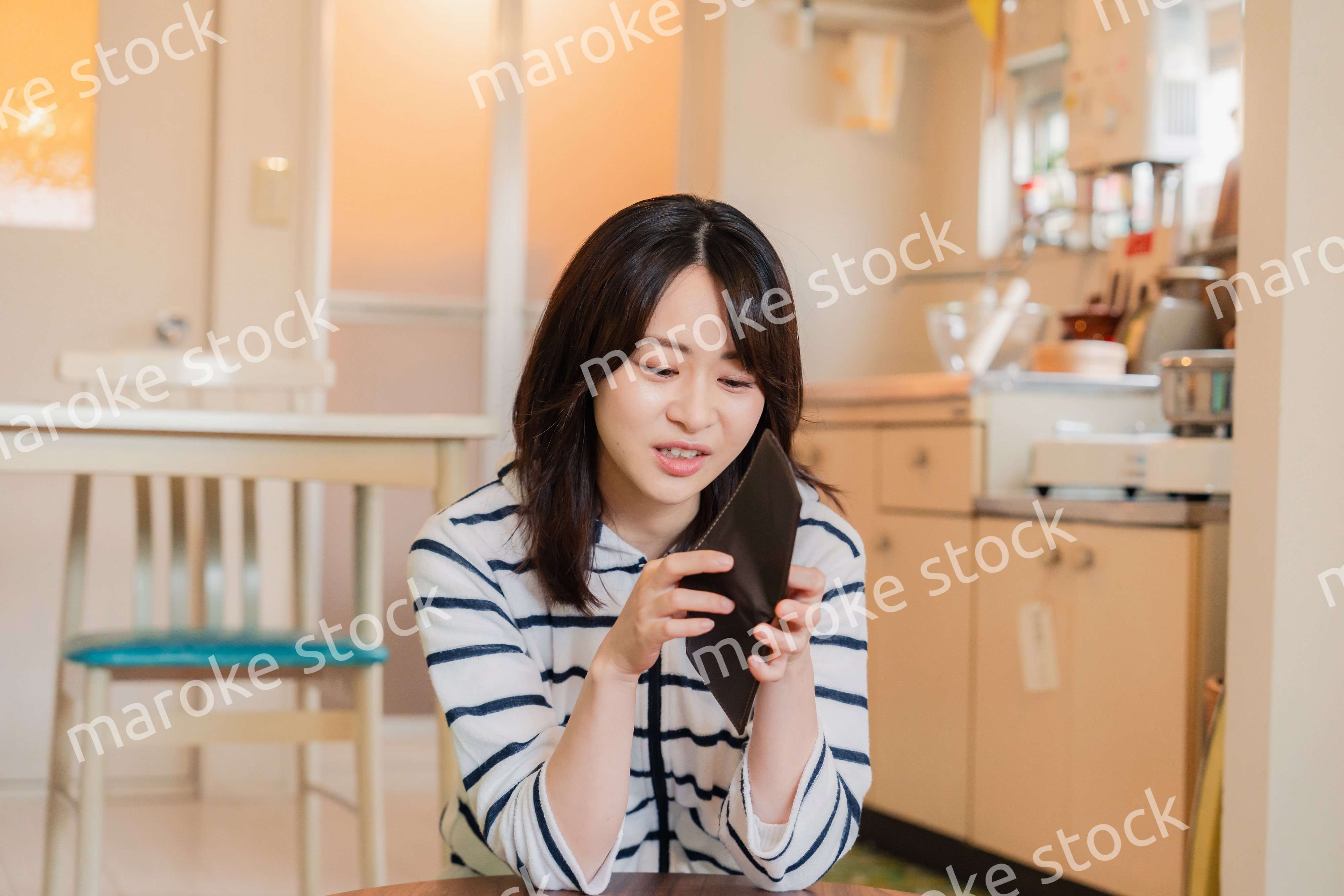 財布の中を確認して落ち込む若い女性