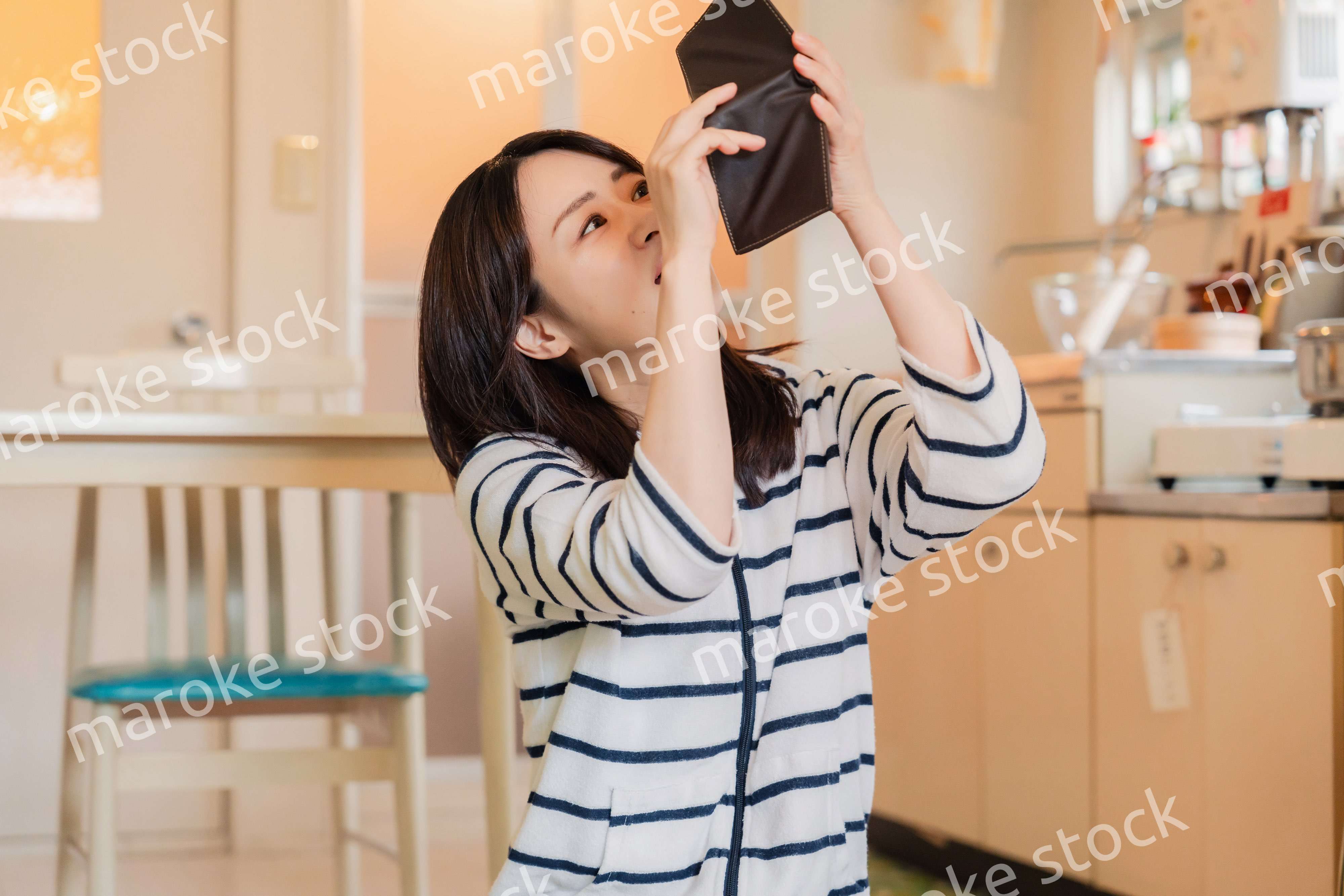 財布の中を確認して落ち込む若い女性