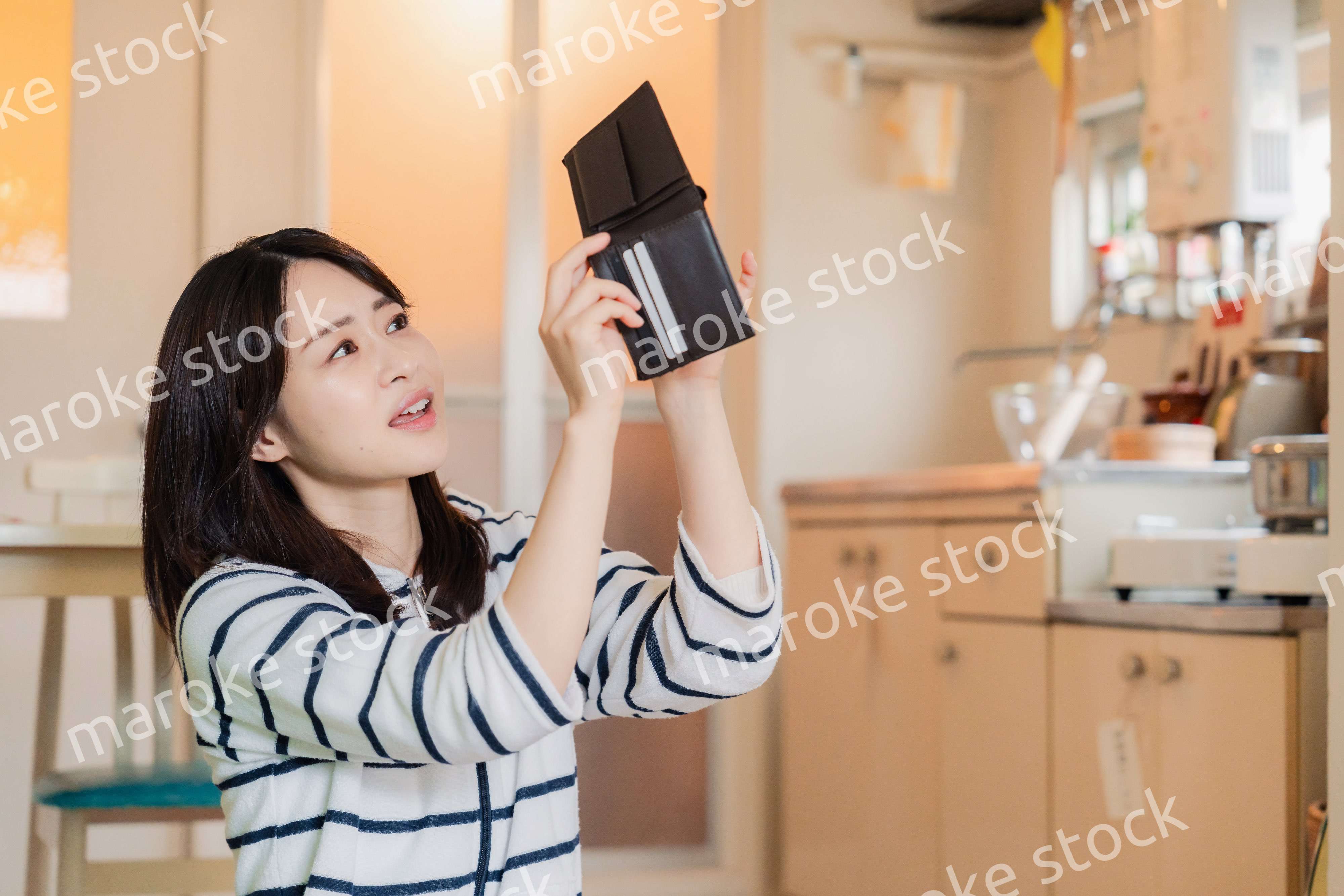 財布の中を確認して落ち込む若い女性