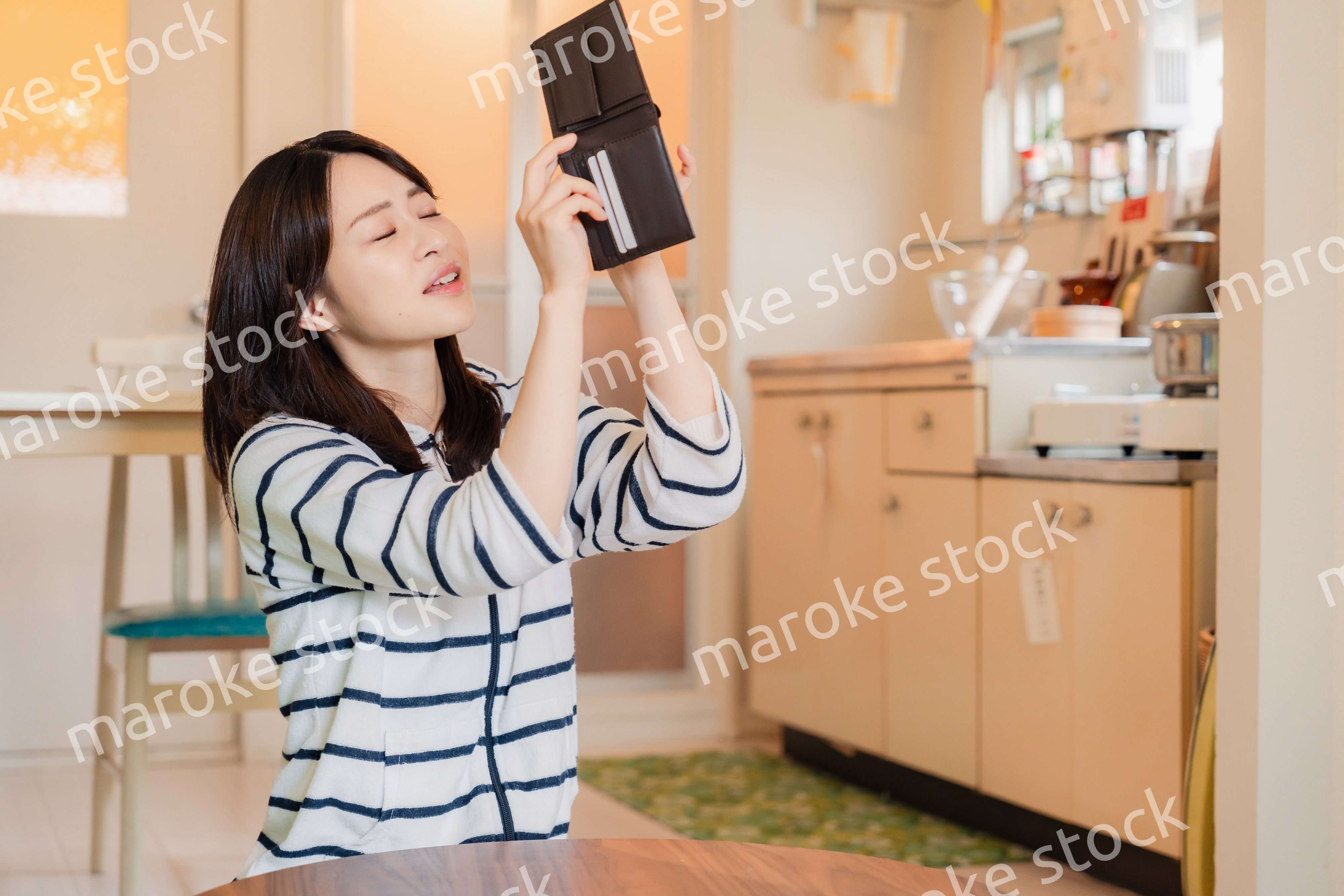 財布の中を確認して落ち込む若い女性