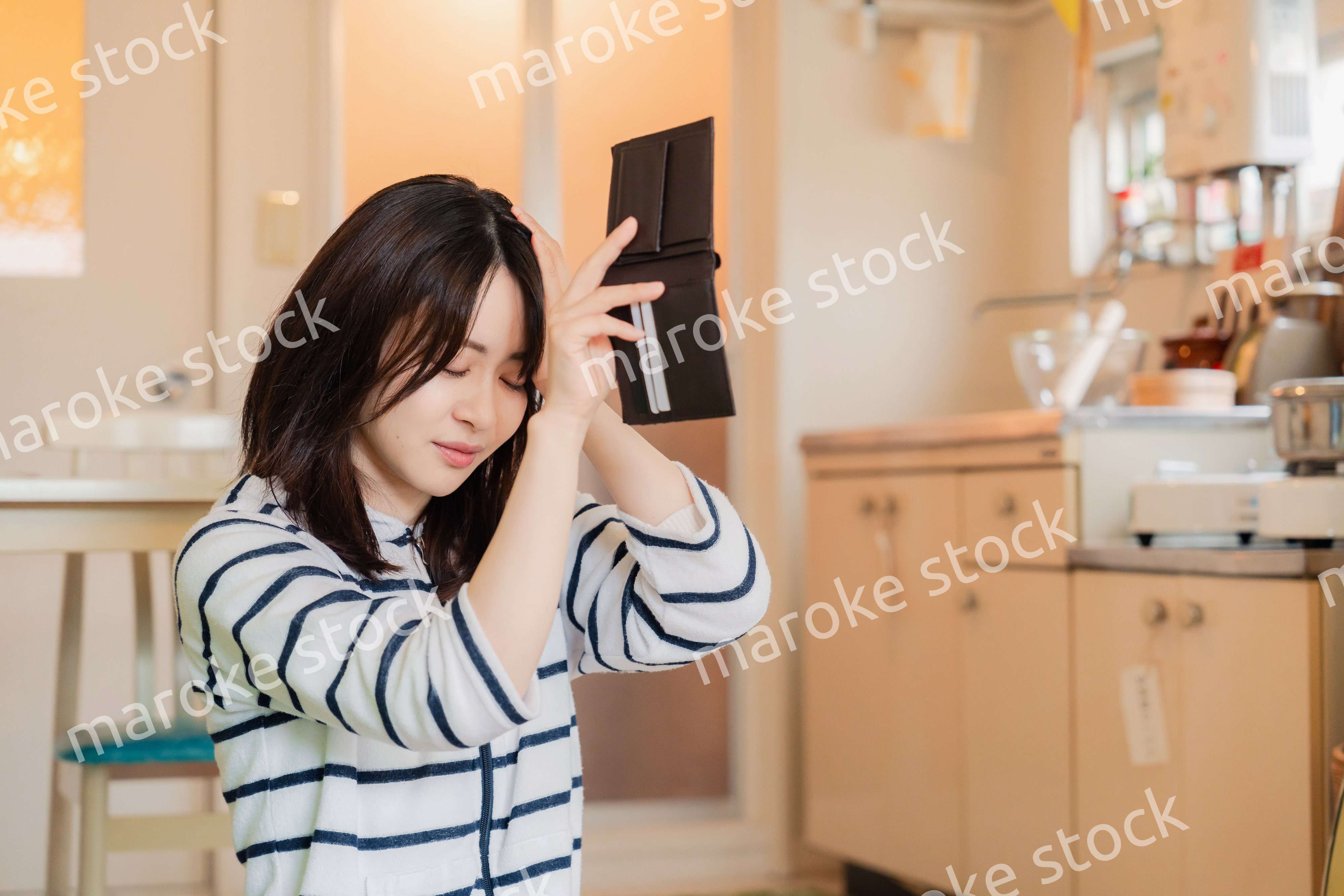 財布の中を確認して落ち込む若い女性