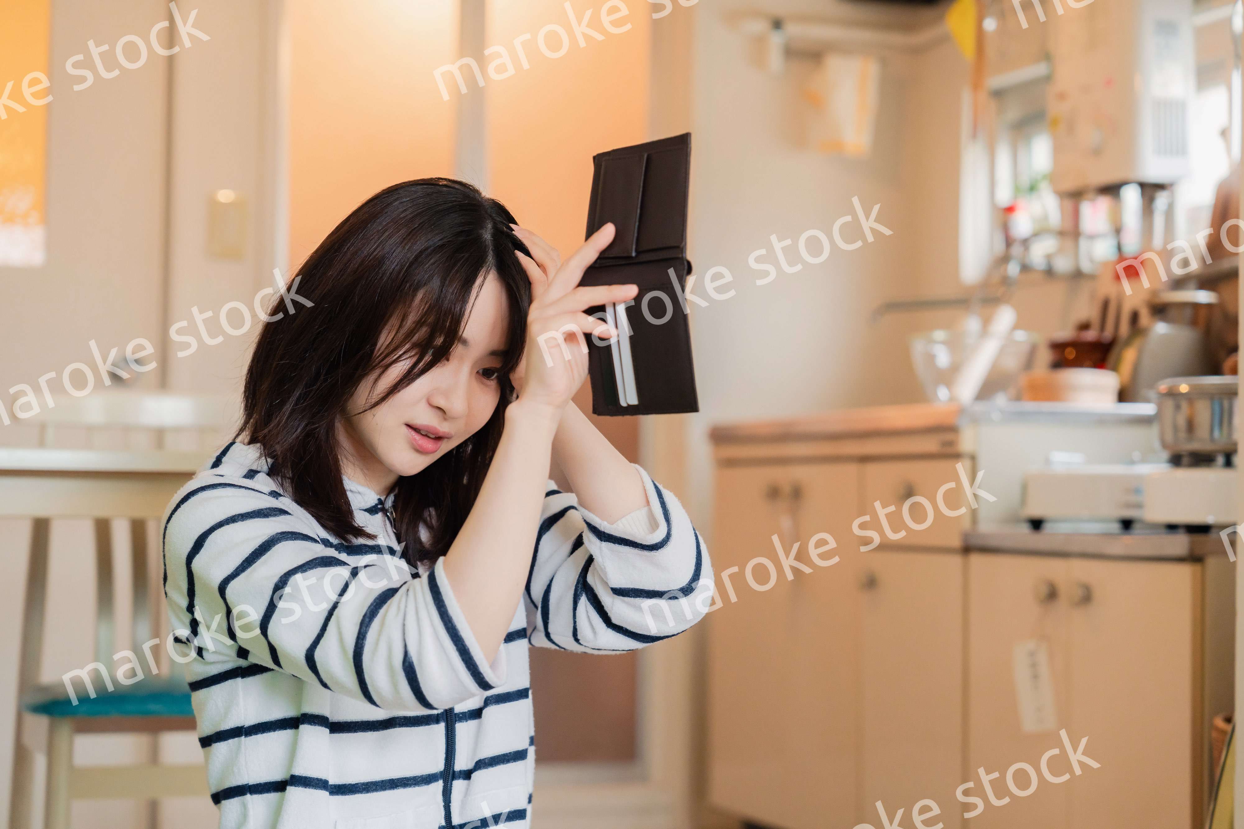 財布の中を確認して落ち込む若い女性