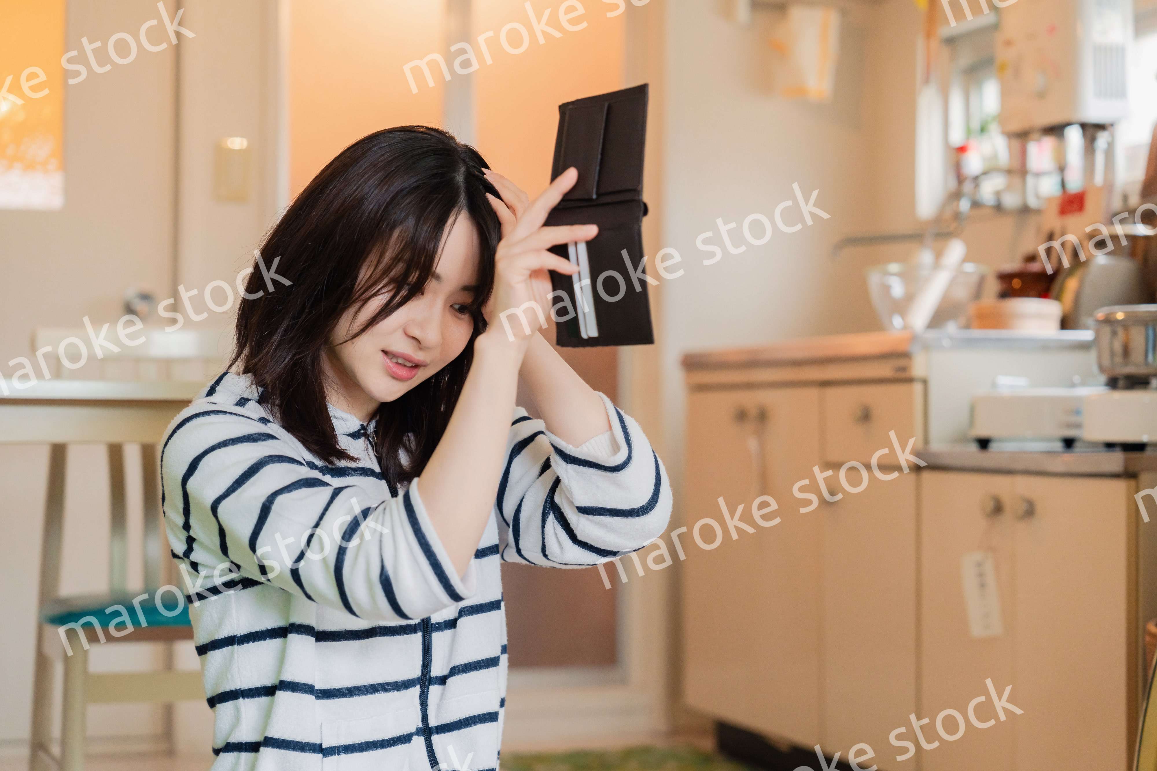 財布の中を確認して落ち込む若い女性