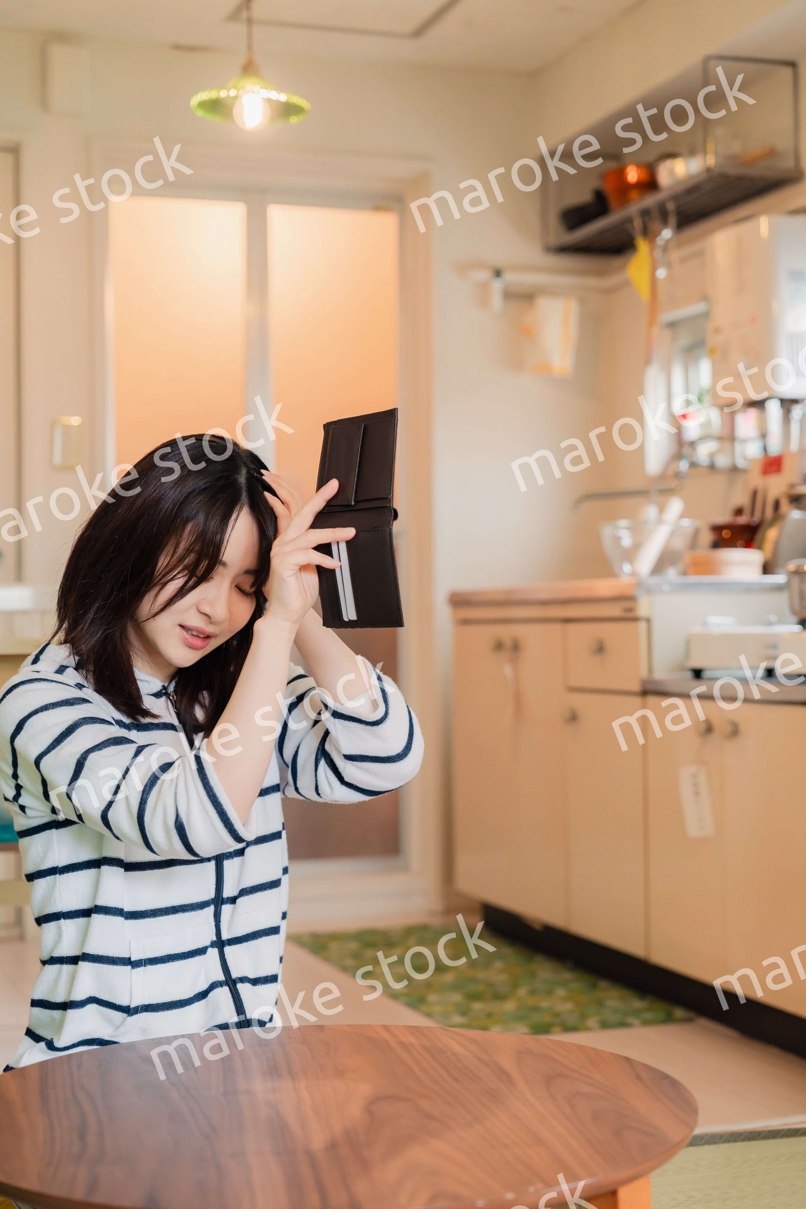 財布の中を確認して落ち込む若い女性