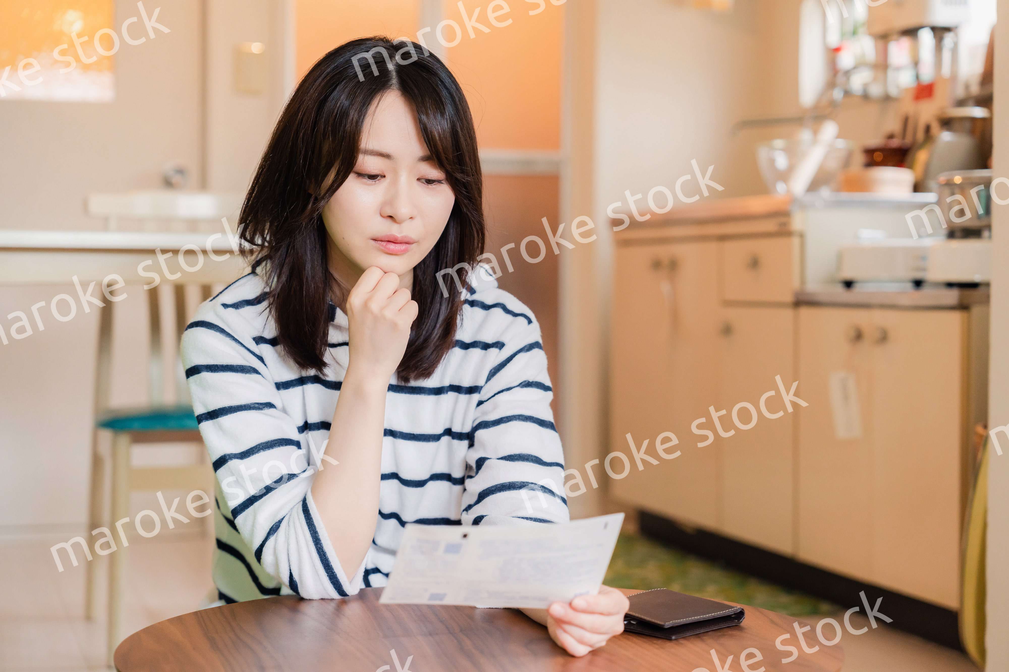 電気料金の高騰で頭を抱える若い女性