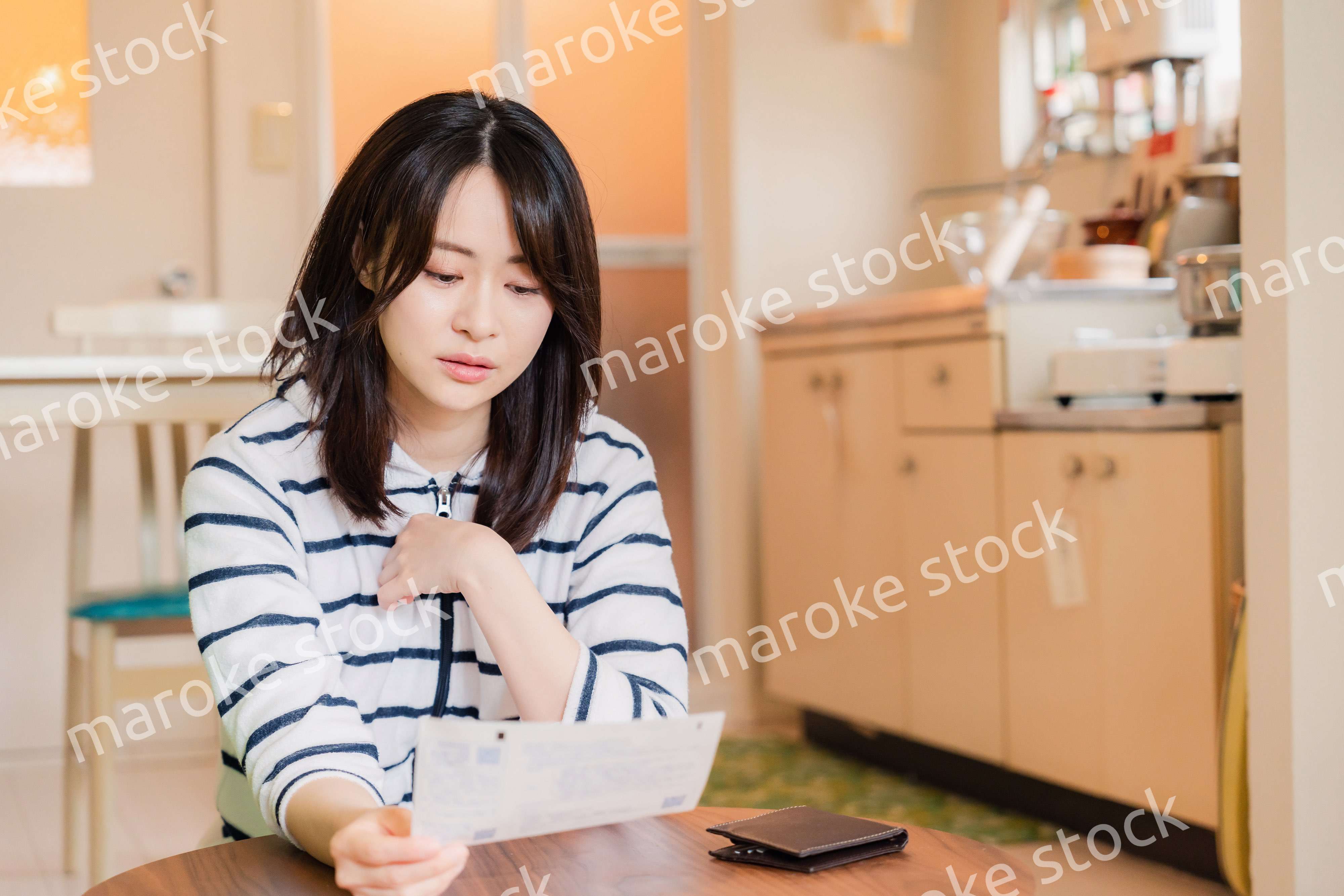 電気料金の高騰で頭を抱える若い女性