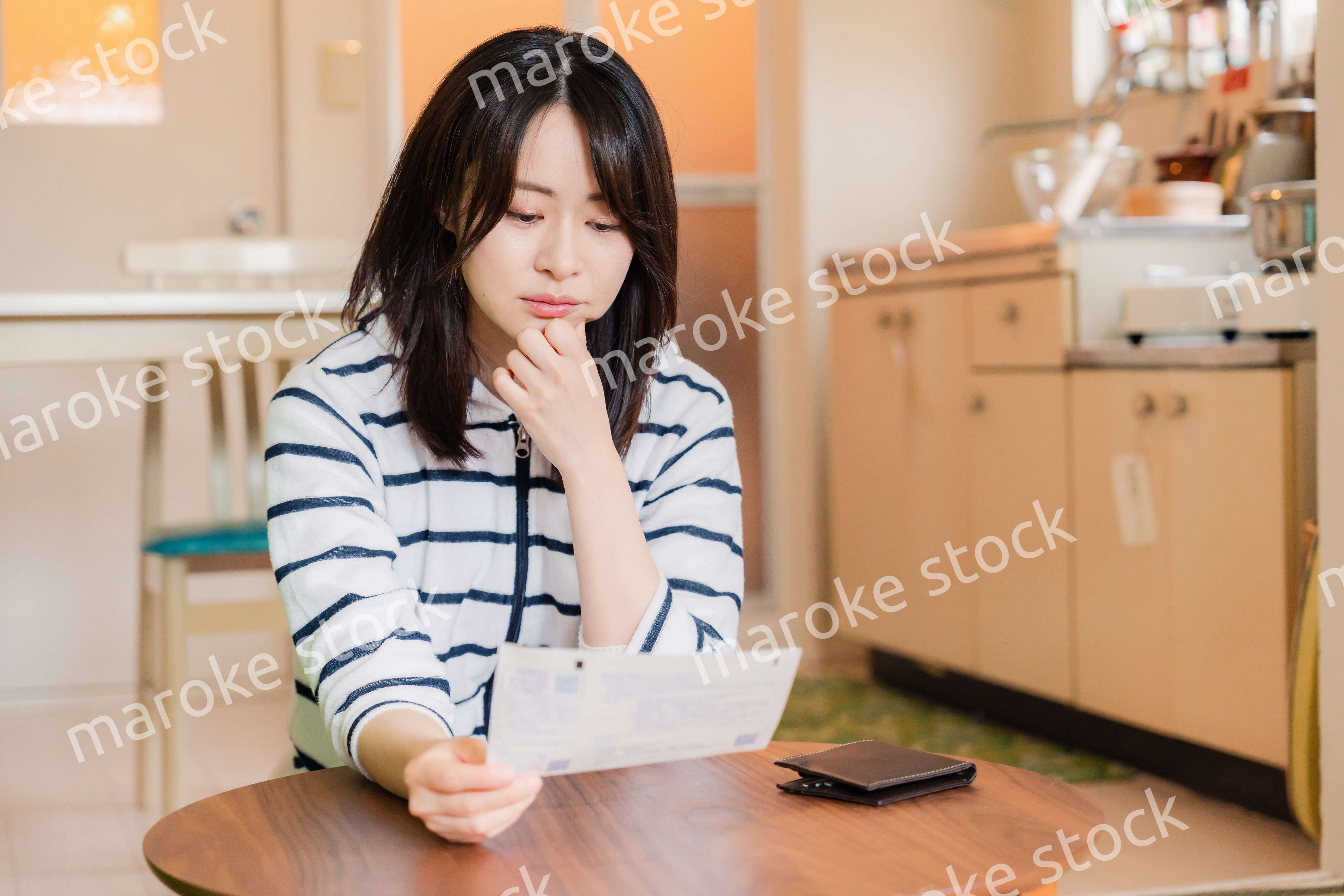 電気料金の高騰で頭を抱える若い女性