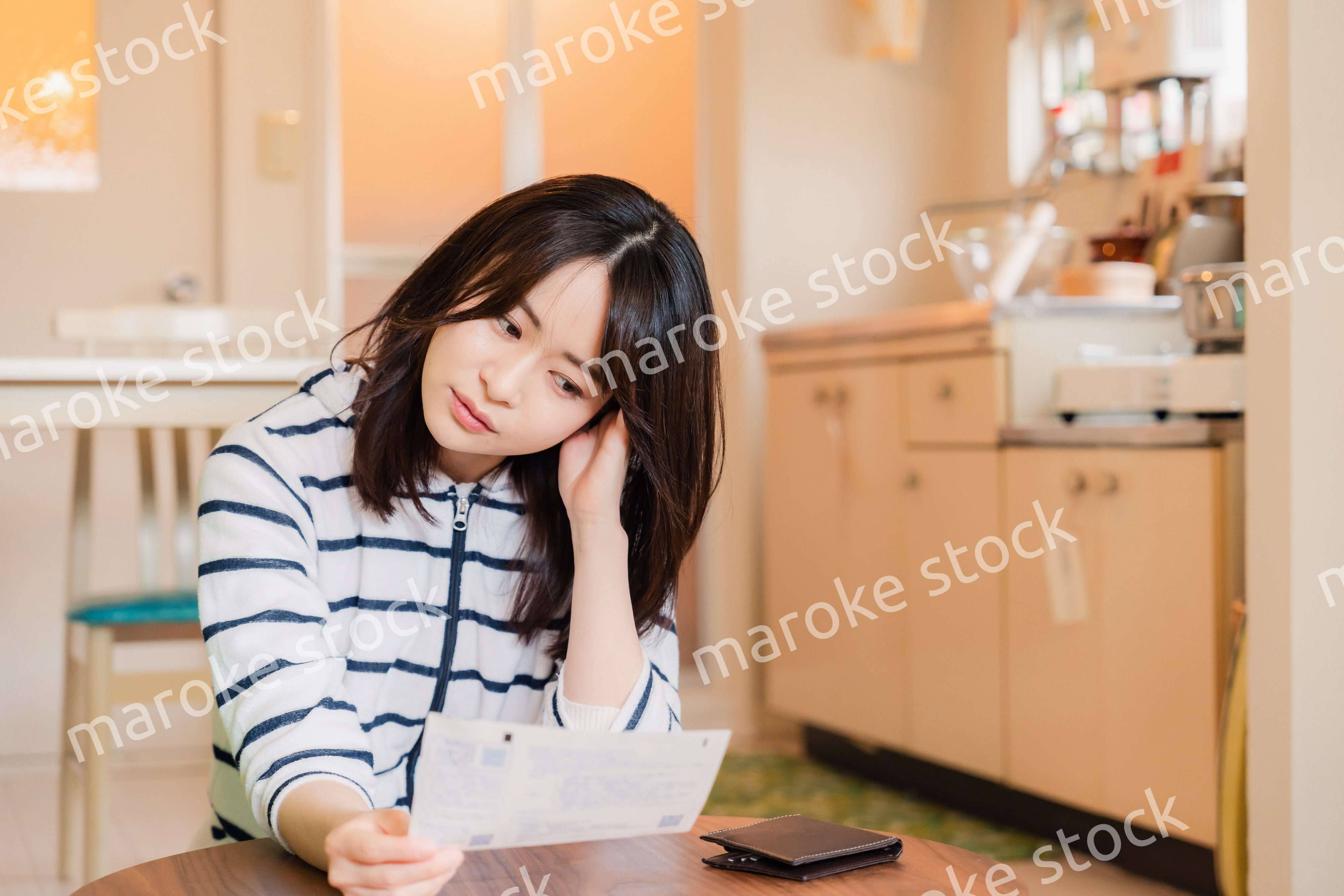 電気料金の高騰で頭を抱える若い女性