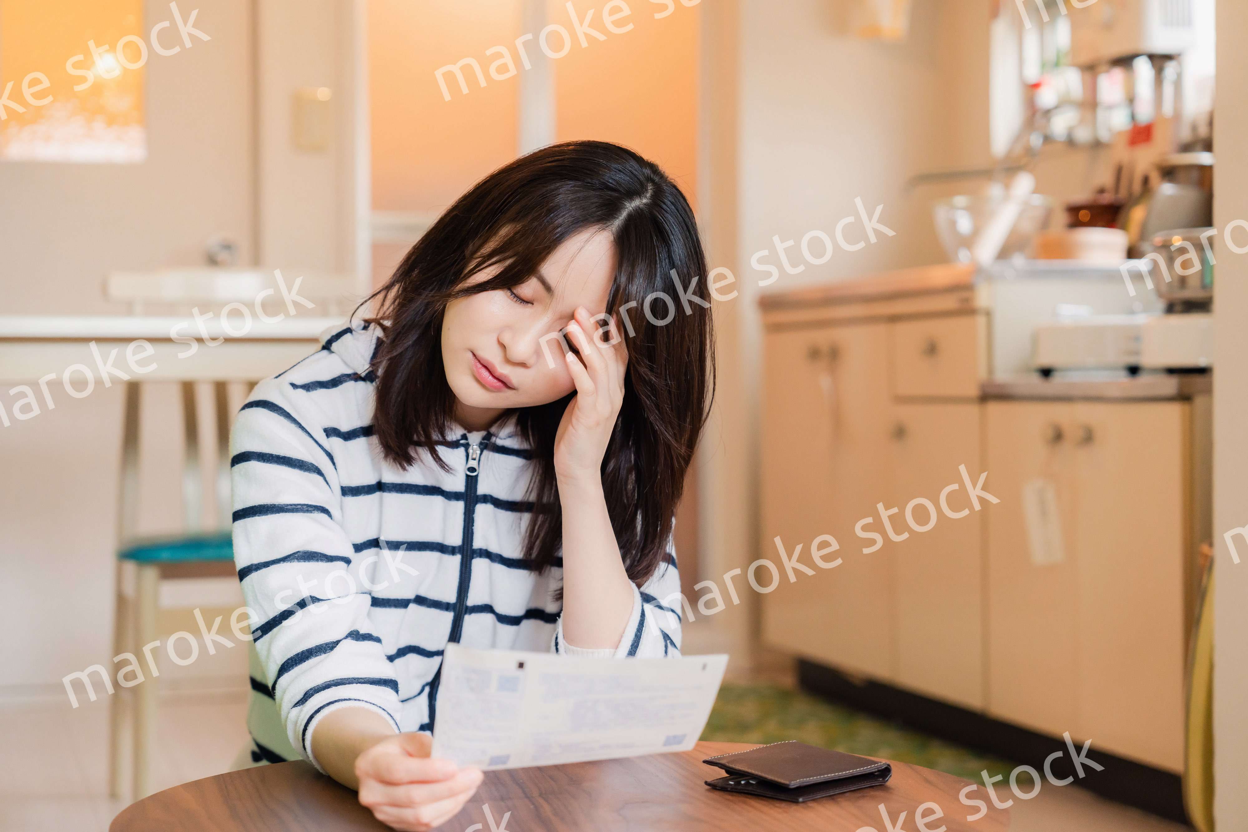 電気料金の高騰で頭を抱える若い女性