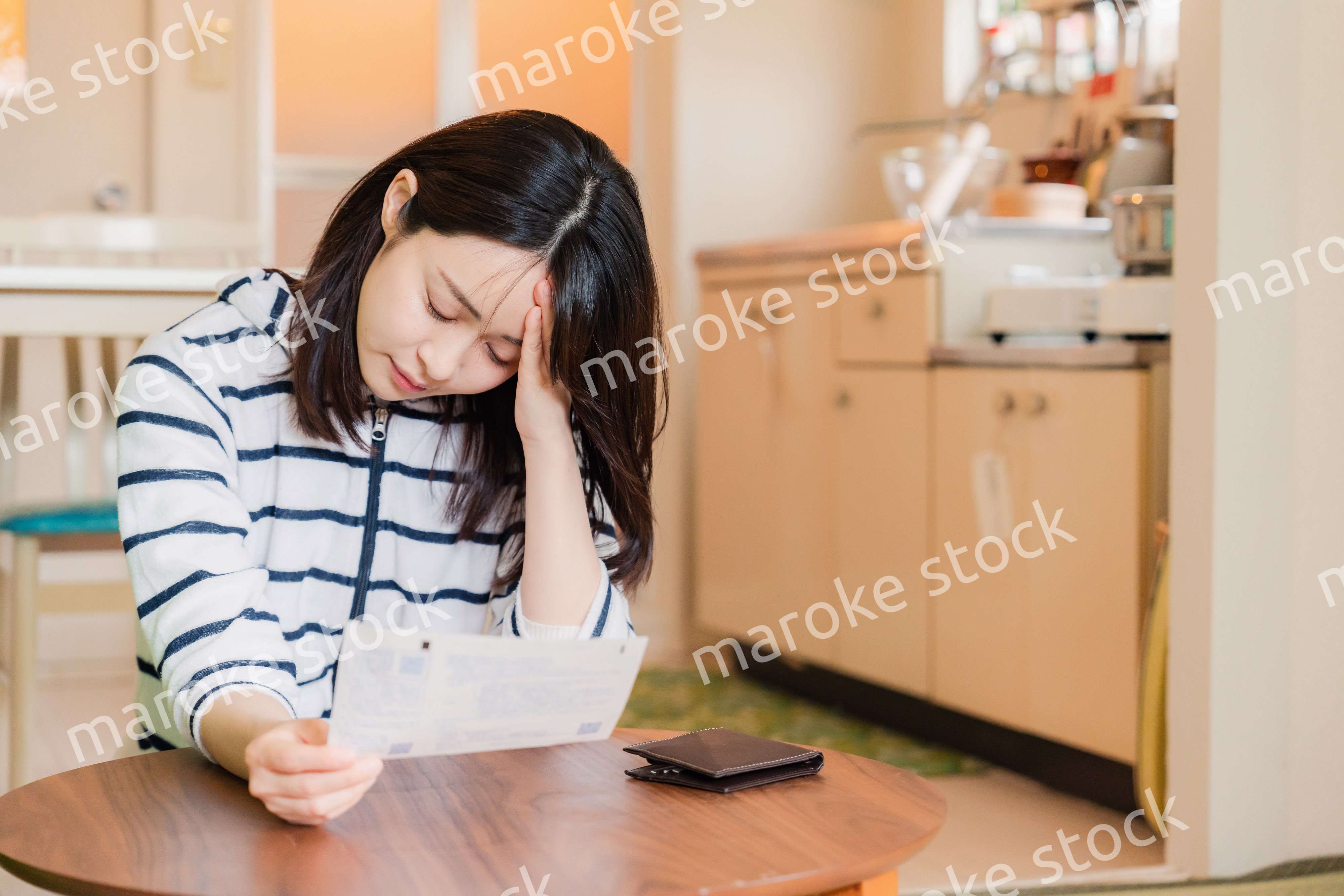 電気料金の高騰で頭を抱える若い女性