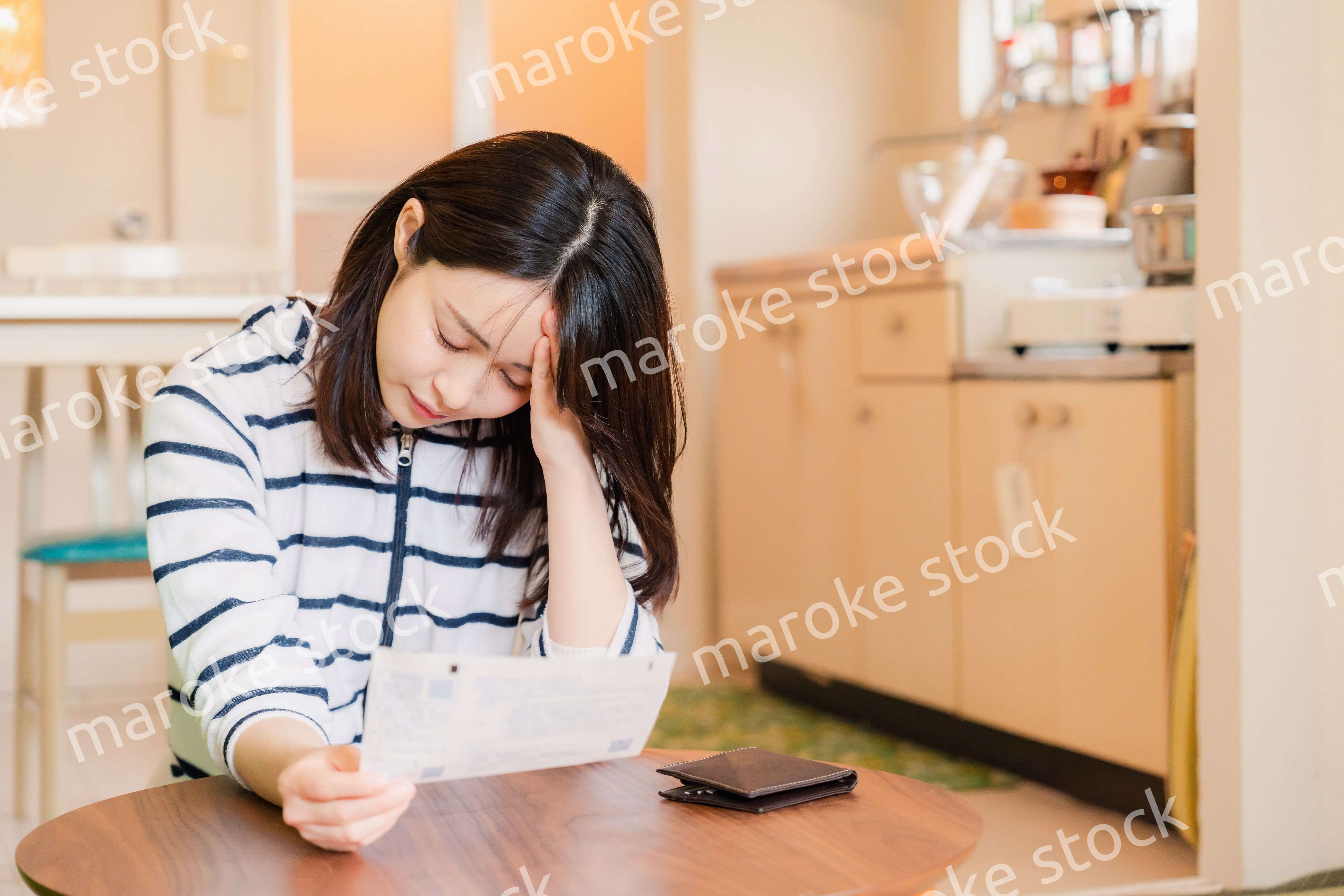 電気料金の高騰で頭を抱える若い女性