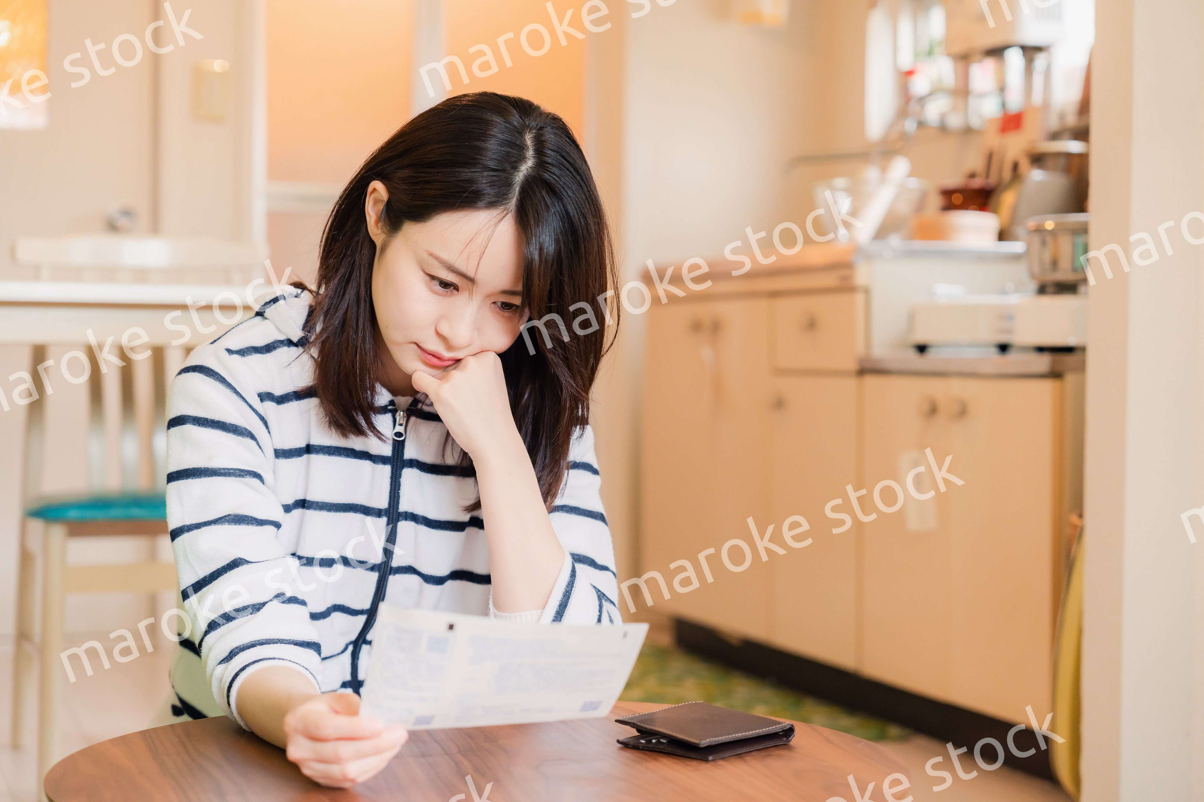 電気料金の高騰で頭を抱える若い女性