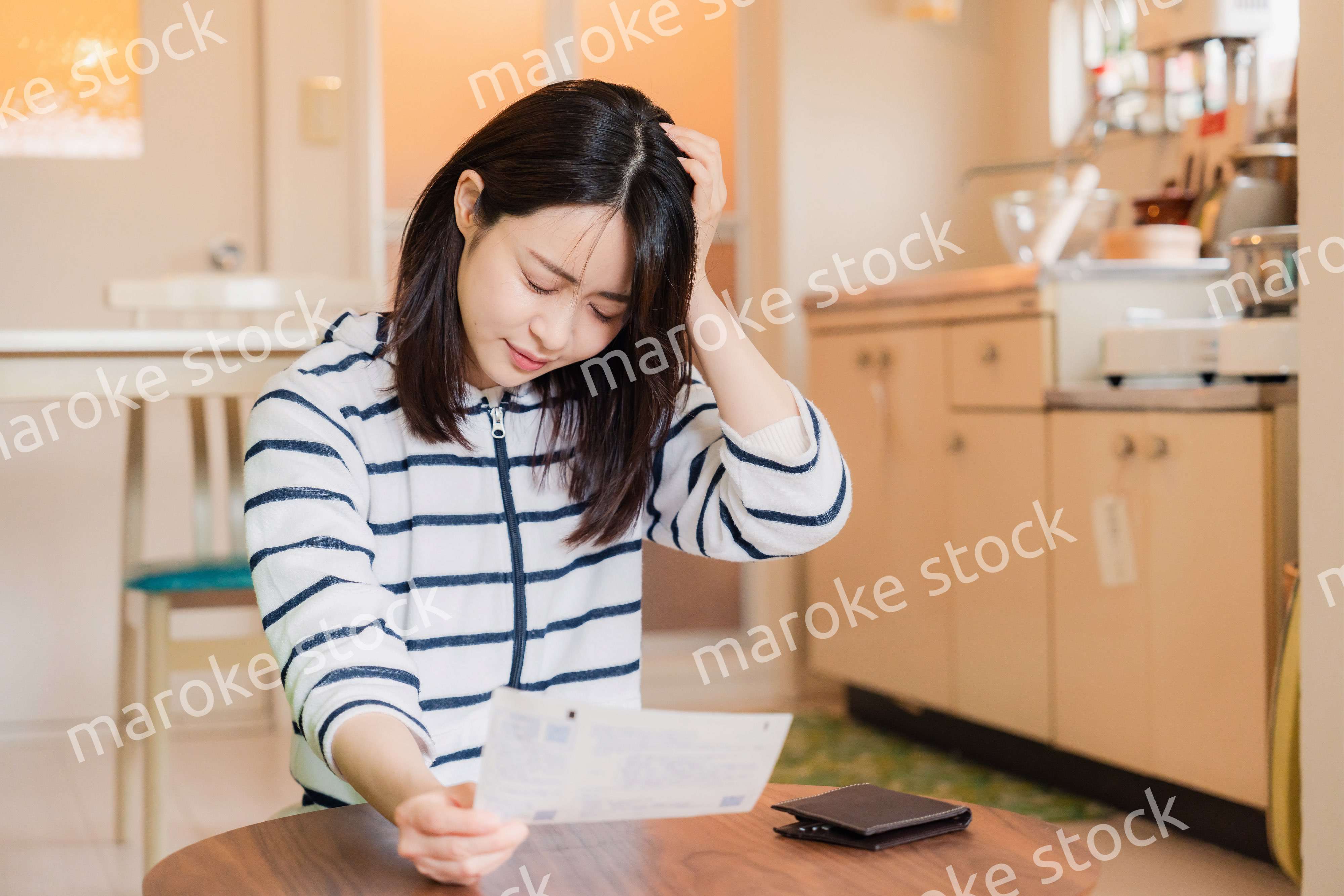 電気料金の高騰で頭を抱える若い女性