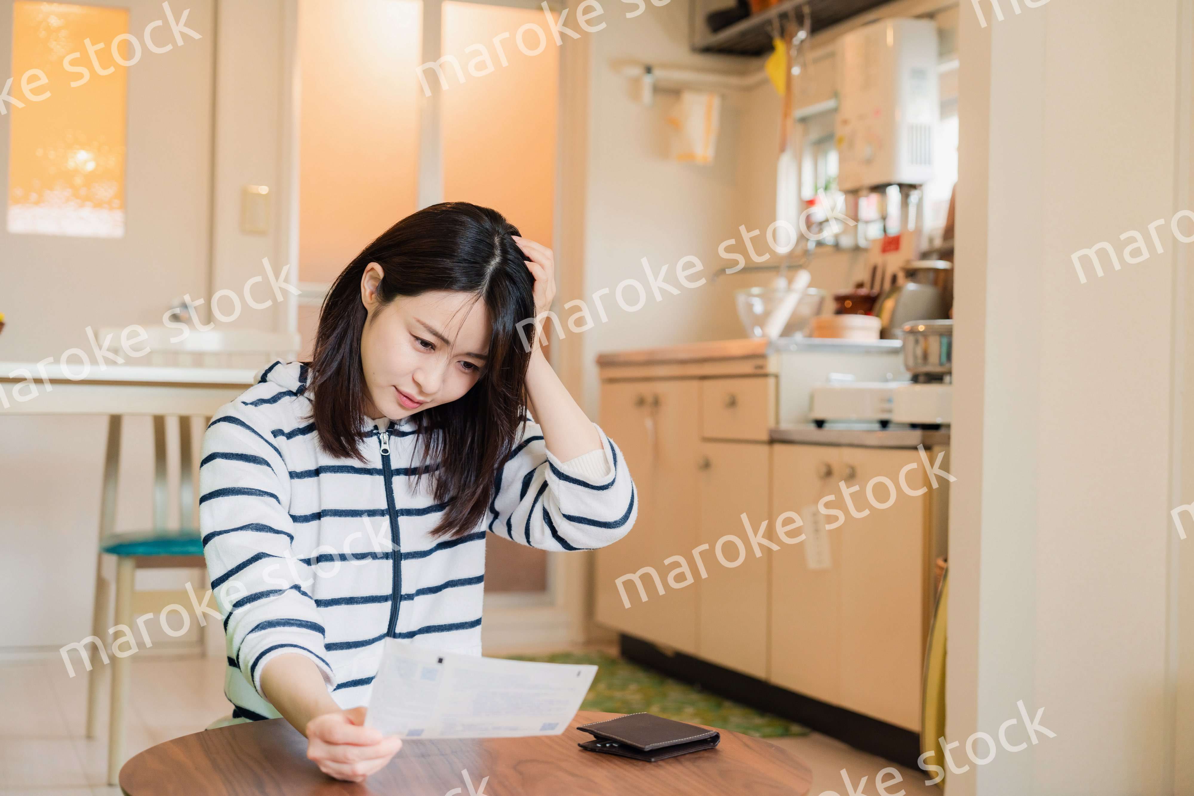 電気料金の高騰で頭を抱える若い女性