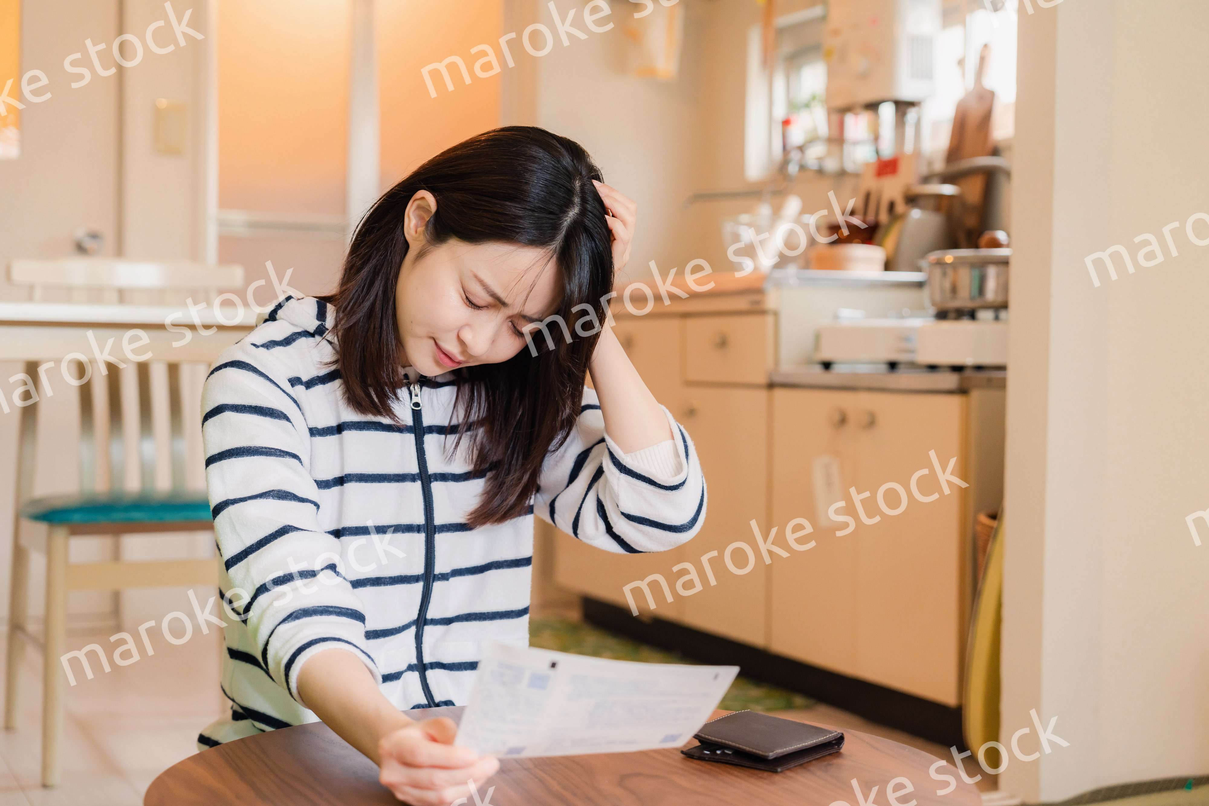 電気料金の高騰で頭を抱える若い女性