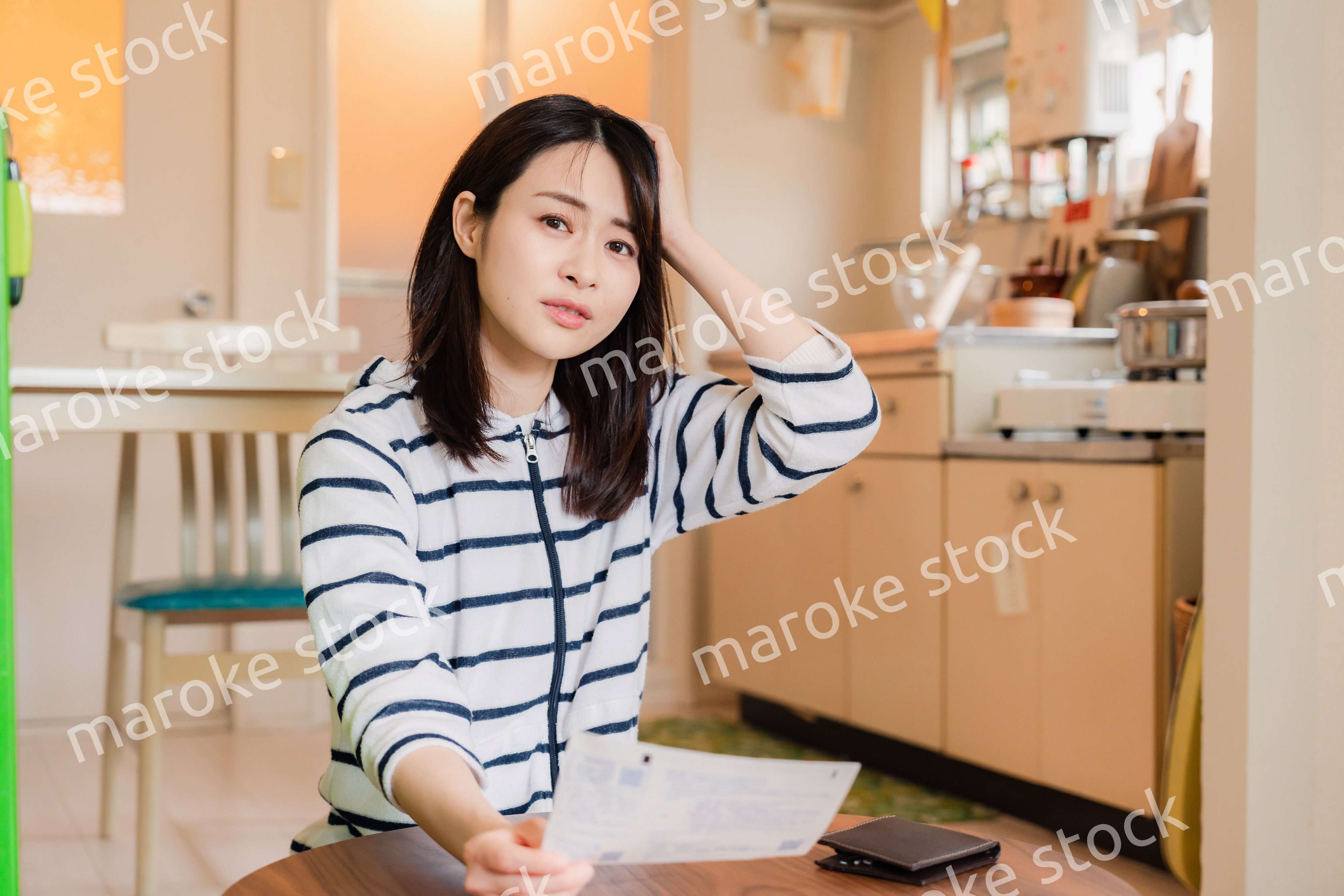 電気料金の高騰で頭を抱える若い女性