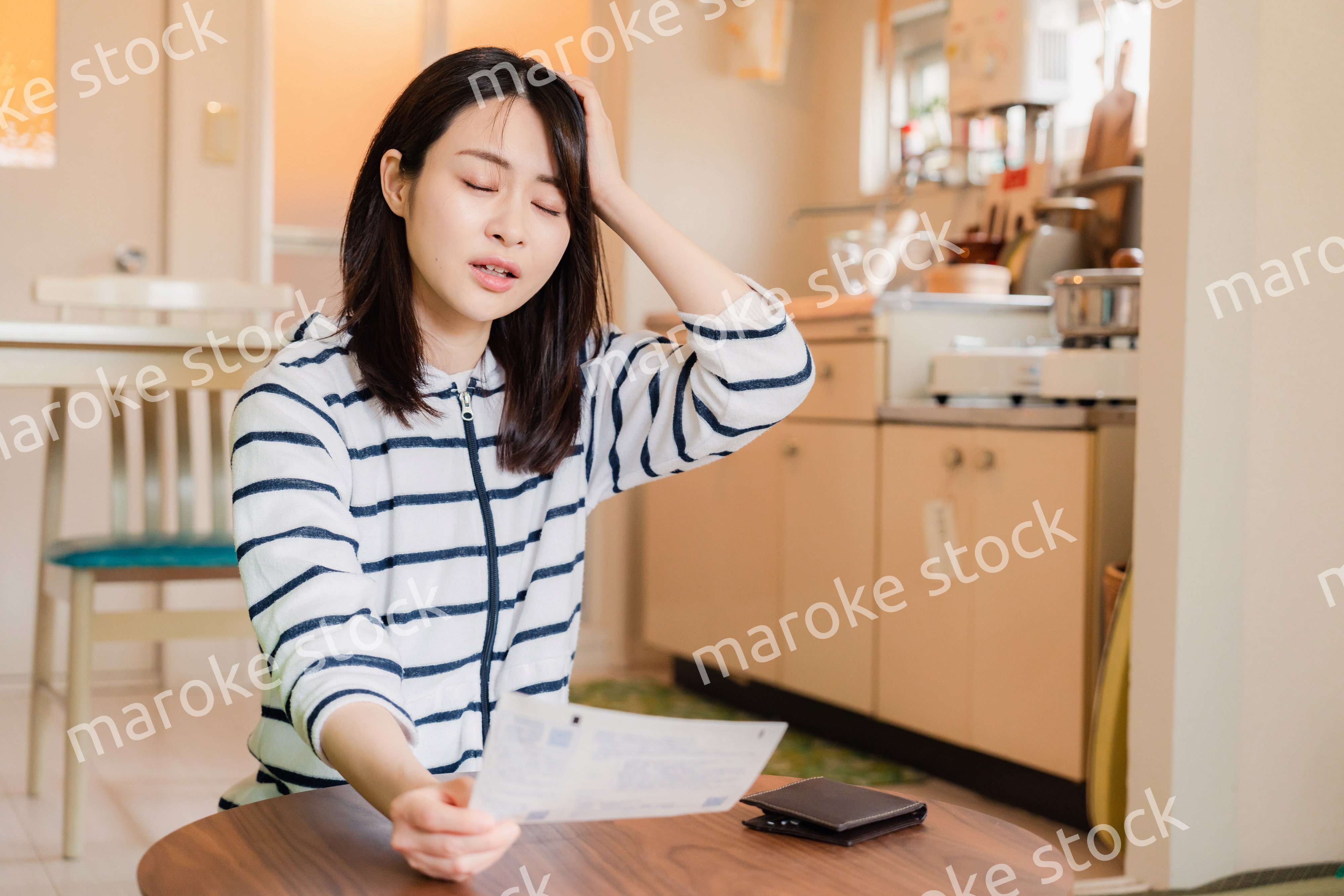 電気料金の高騰で頭を抱える若い女性