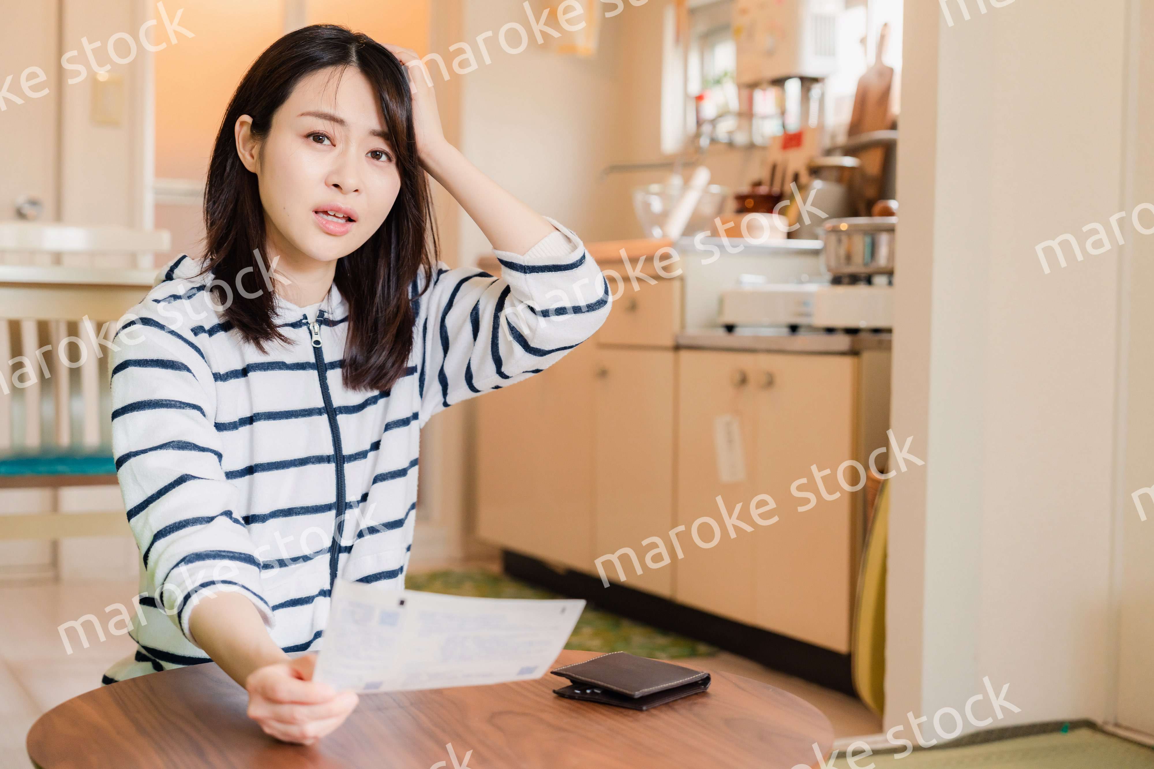 電気料金の高騰で頭を抱える若い女性