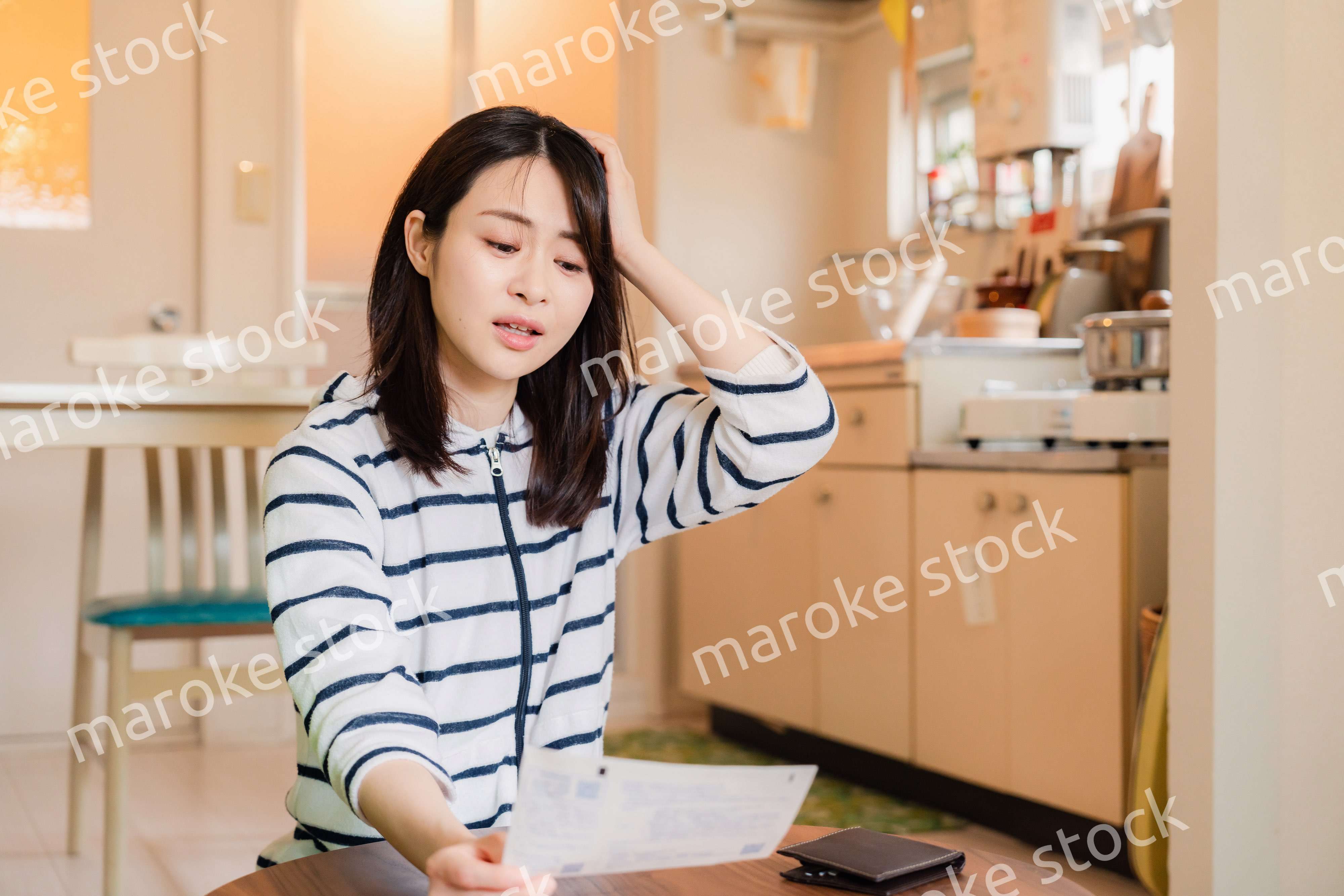 電気料金の高騰で頭を抱える若い女性