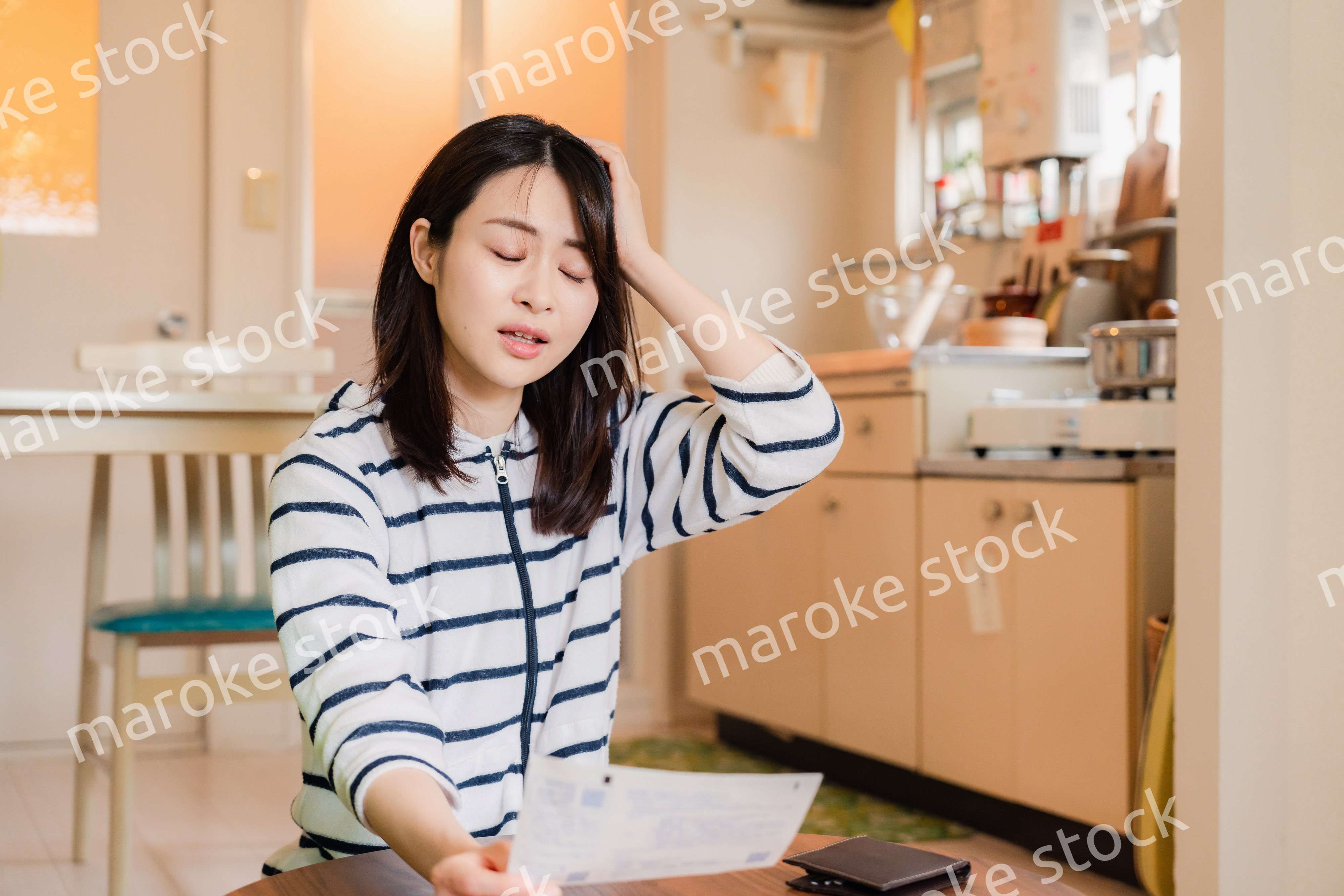 電気料金の高騰で頭を抱える若い女性