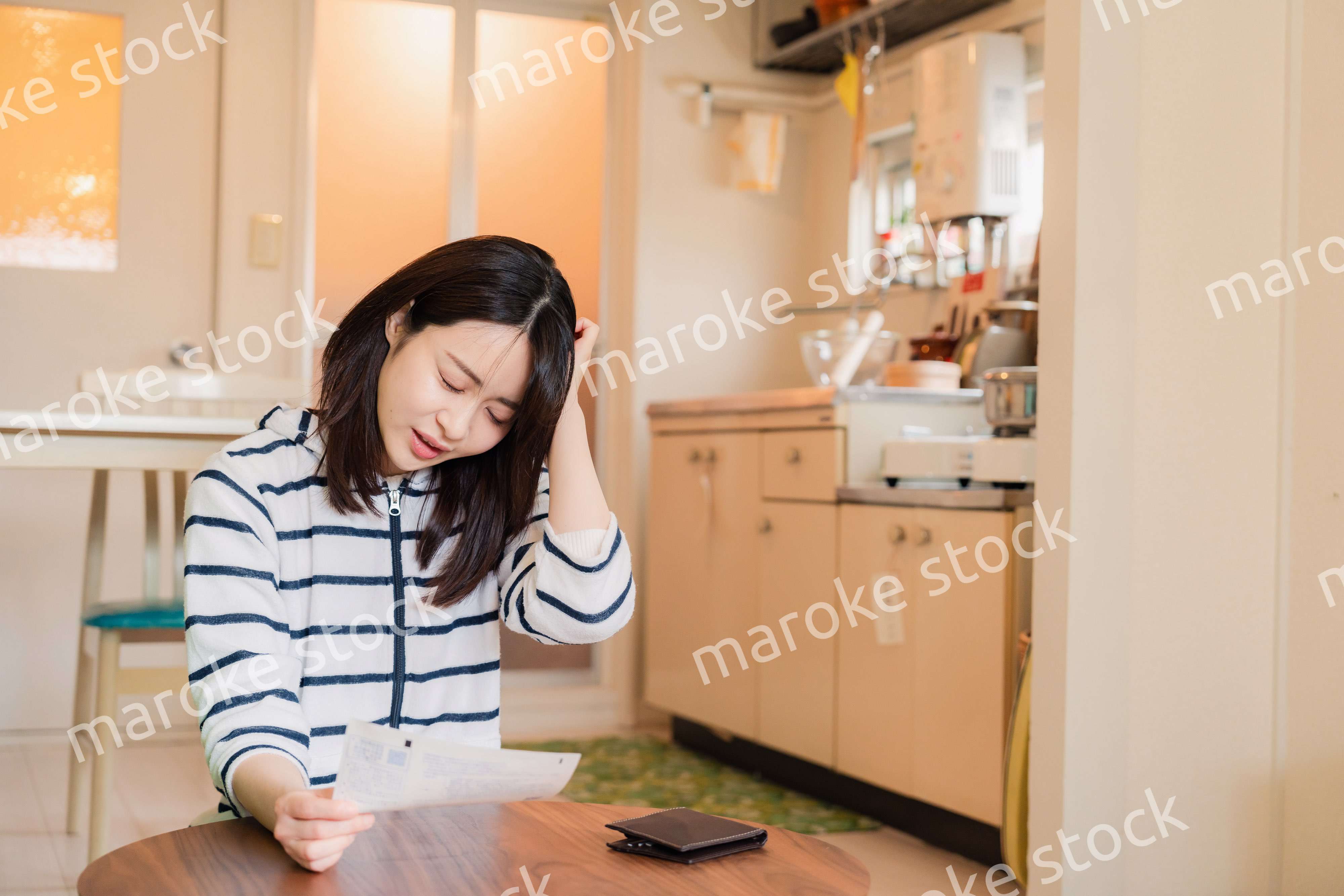 電気料金の高騰で頭を抱える若い女性