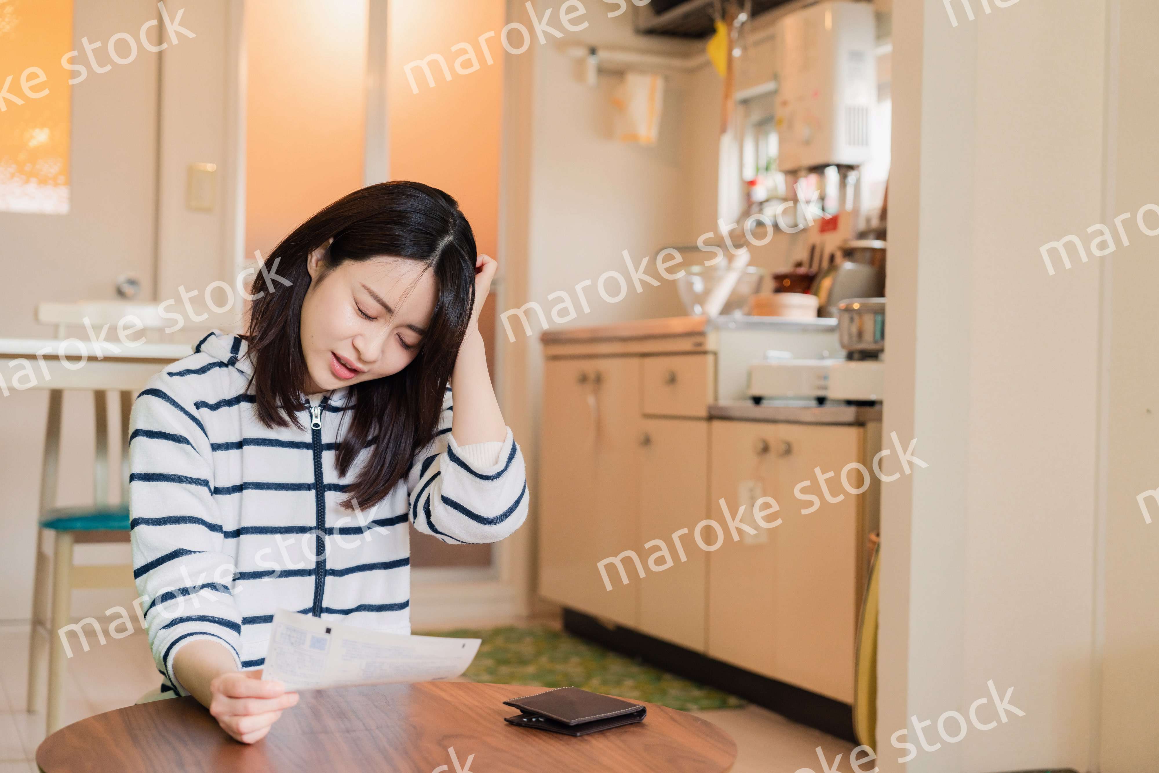 電気料金の高騰で頭を抱える若い女性