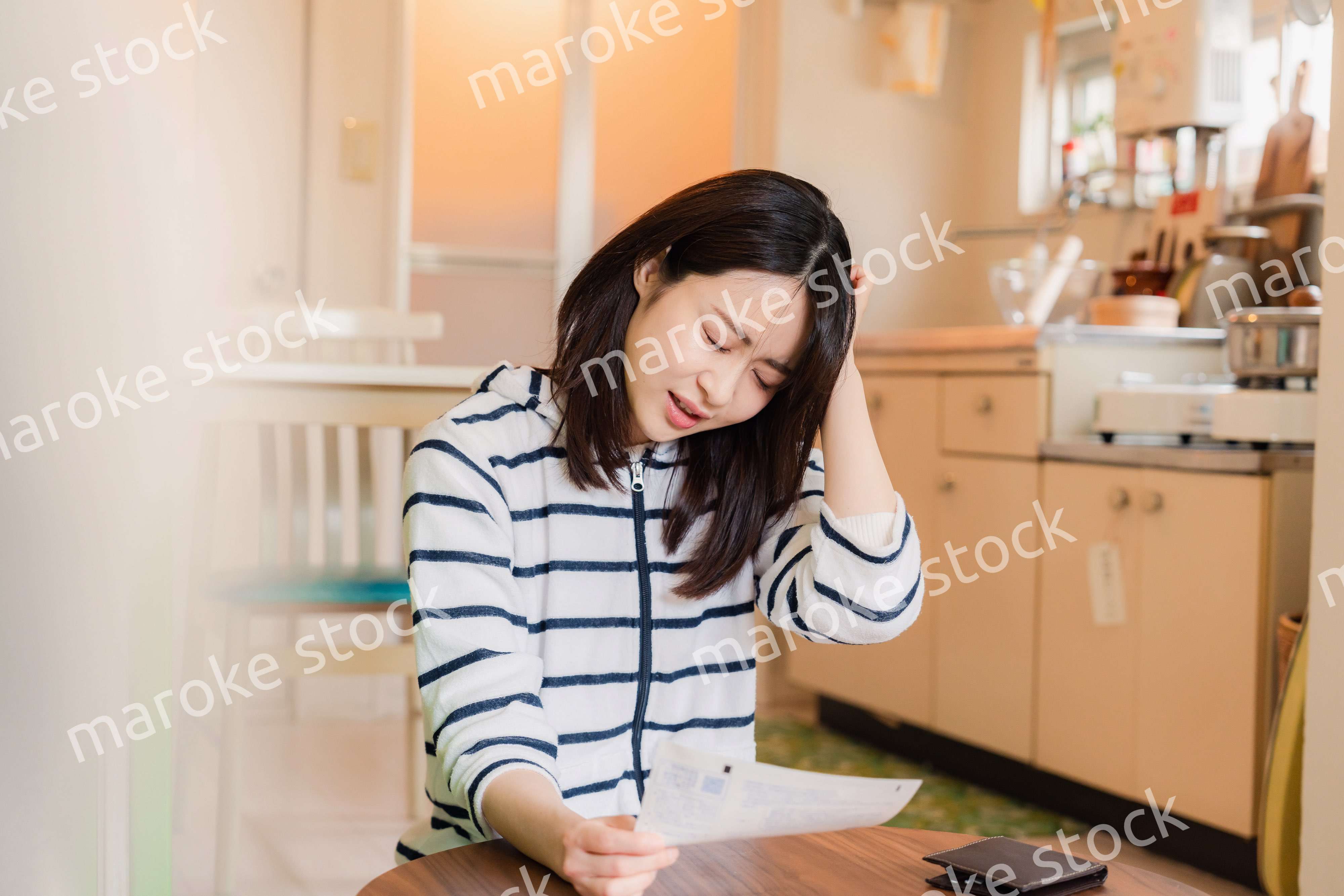 電気料金の高騰で頭を抱える若い女性