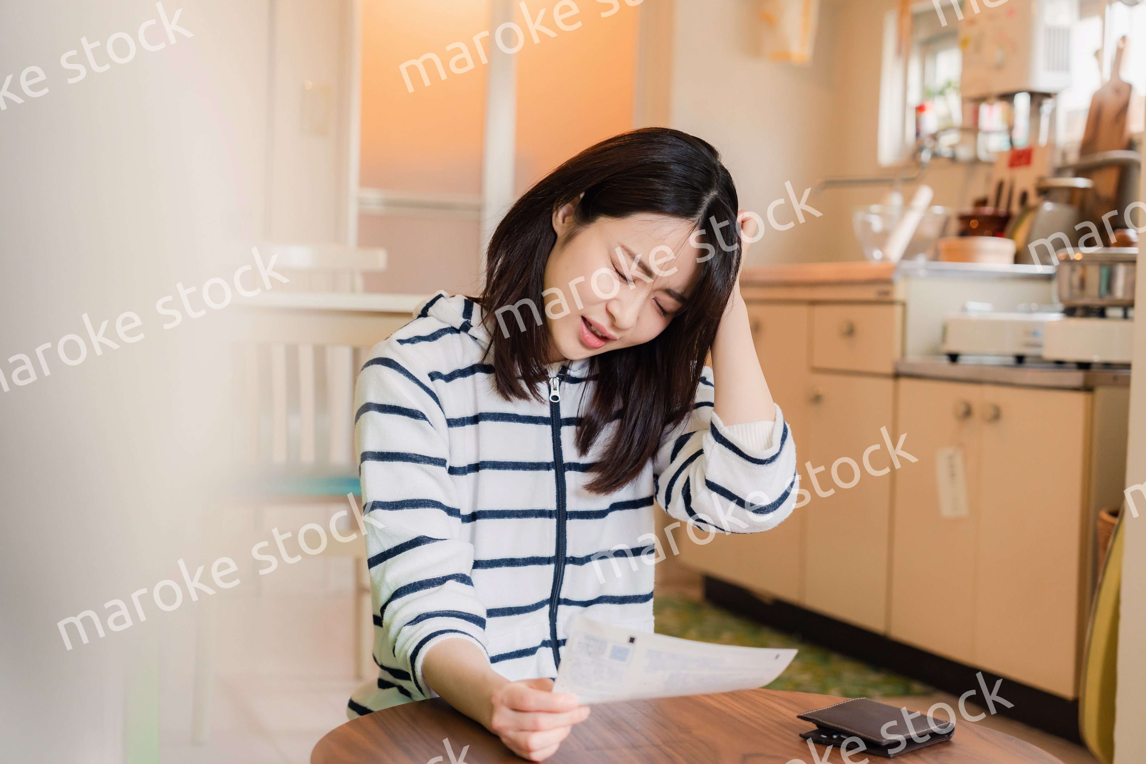 電気料金の高騰で頭を抱える若い女性