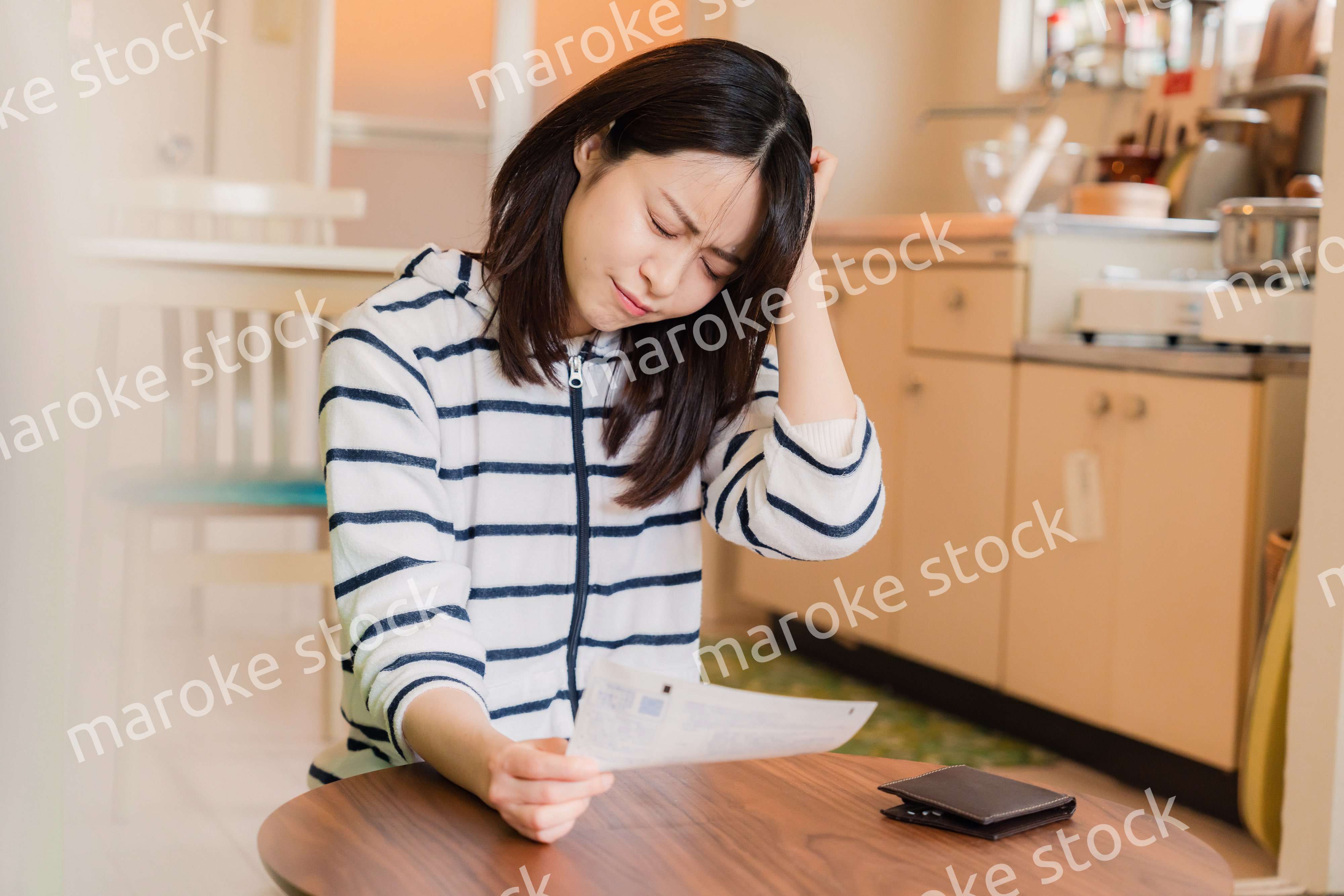 電気料金の高騰で頭を抱える若い女性