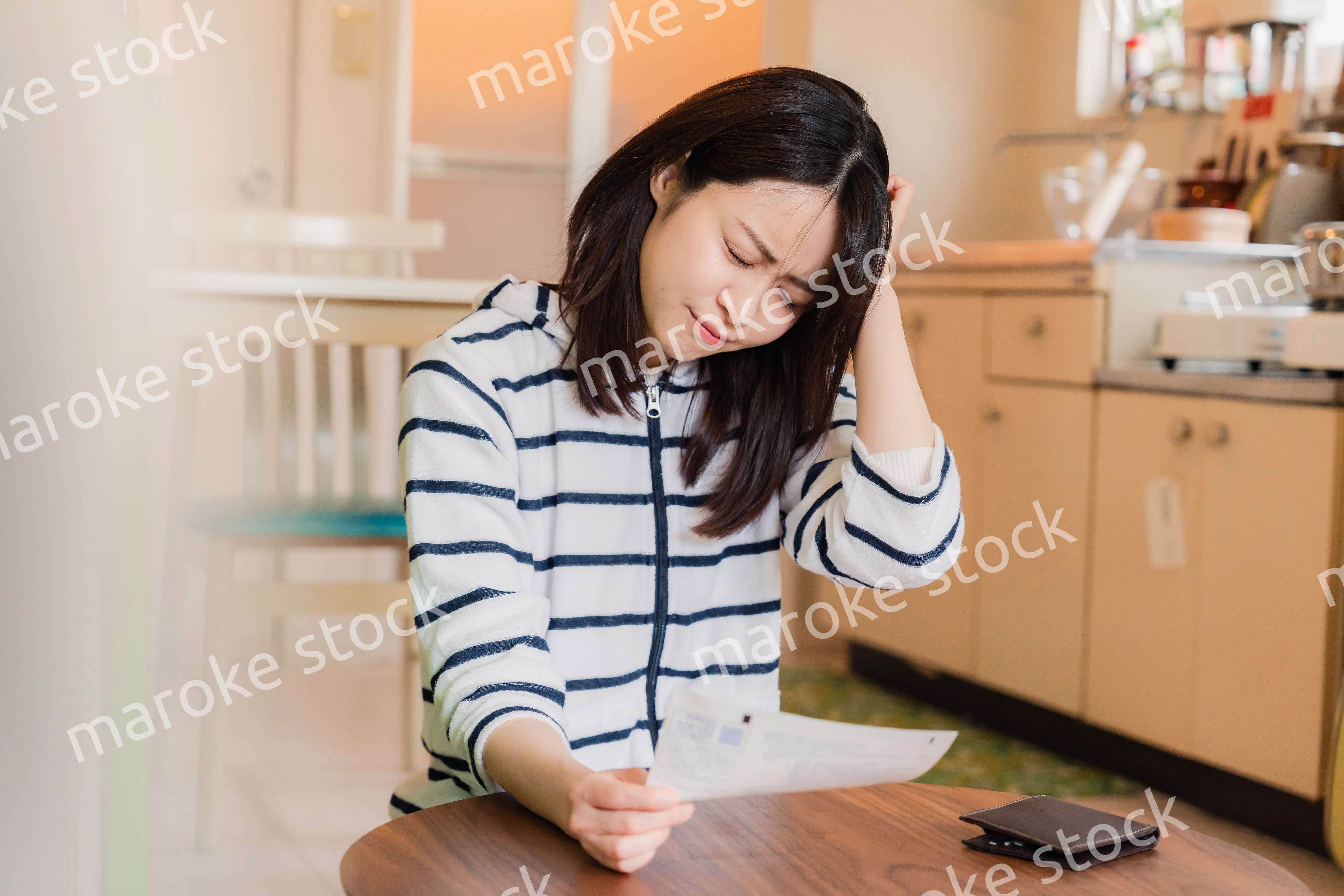 電気料金の高騰で頭を抱える若い女性
