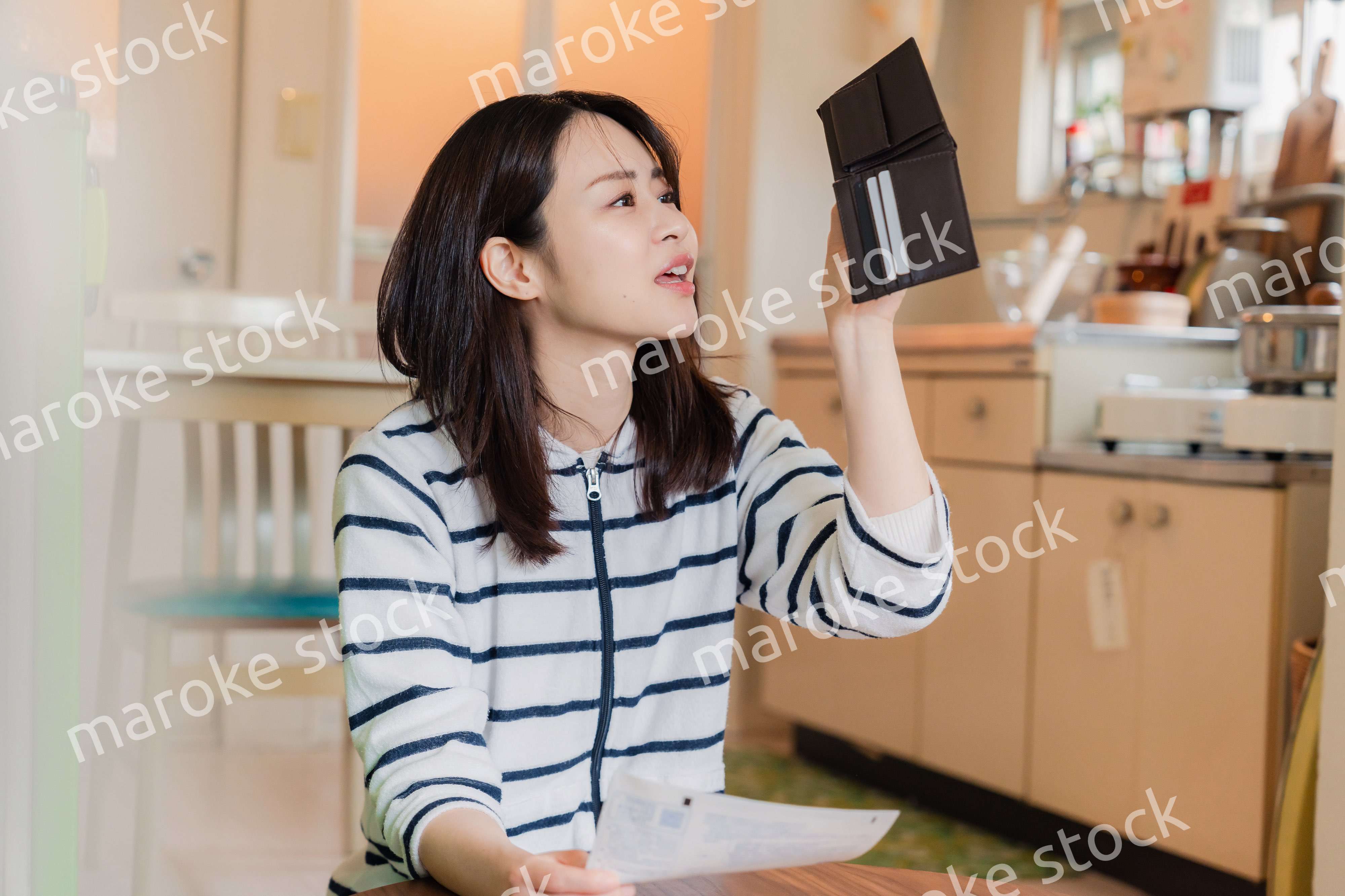 財布の中を確認して落ち込む若い女性