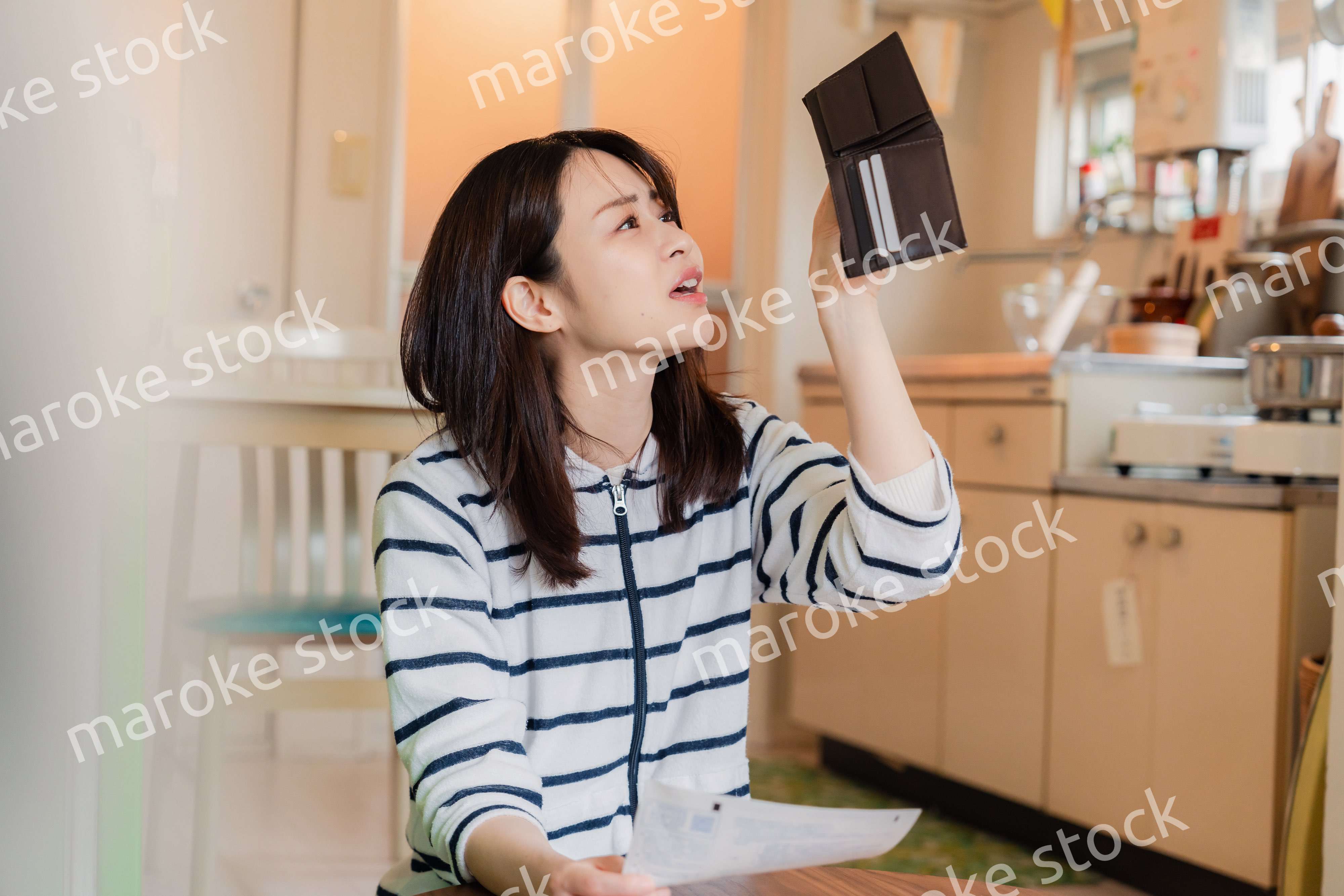 財布の中を確認して落ち込む若い女性