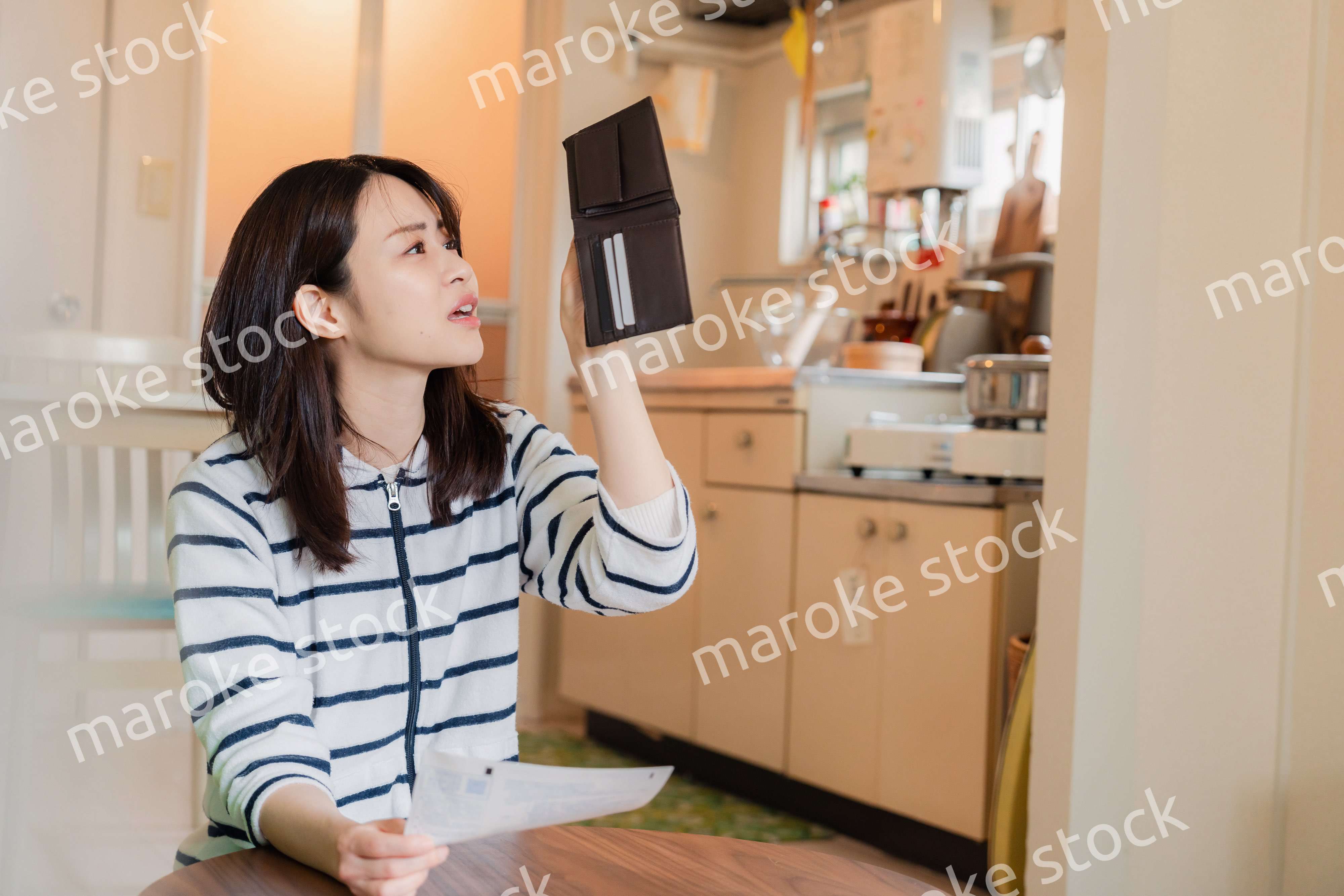 財布の中を確認して落ち込む若い女性