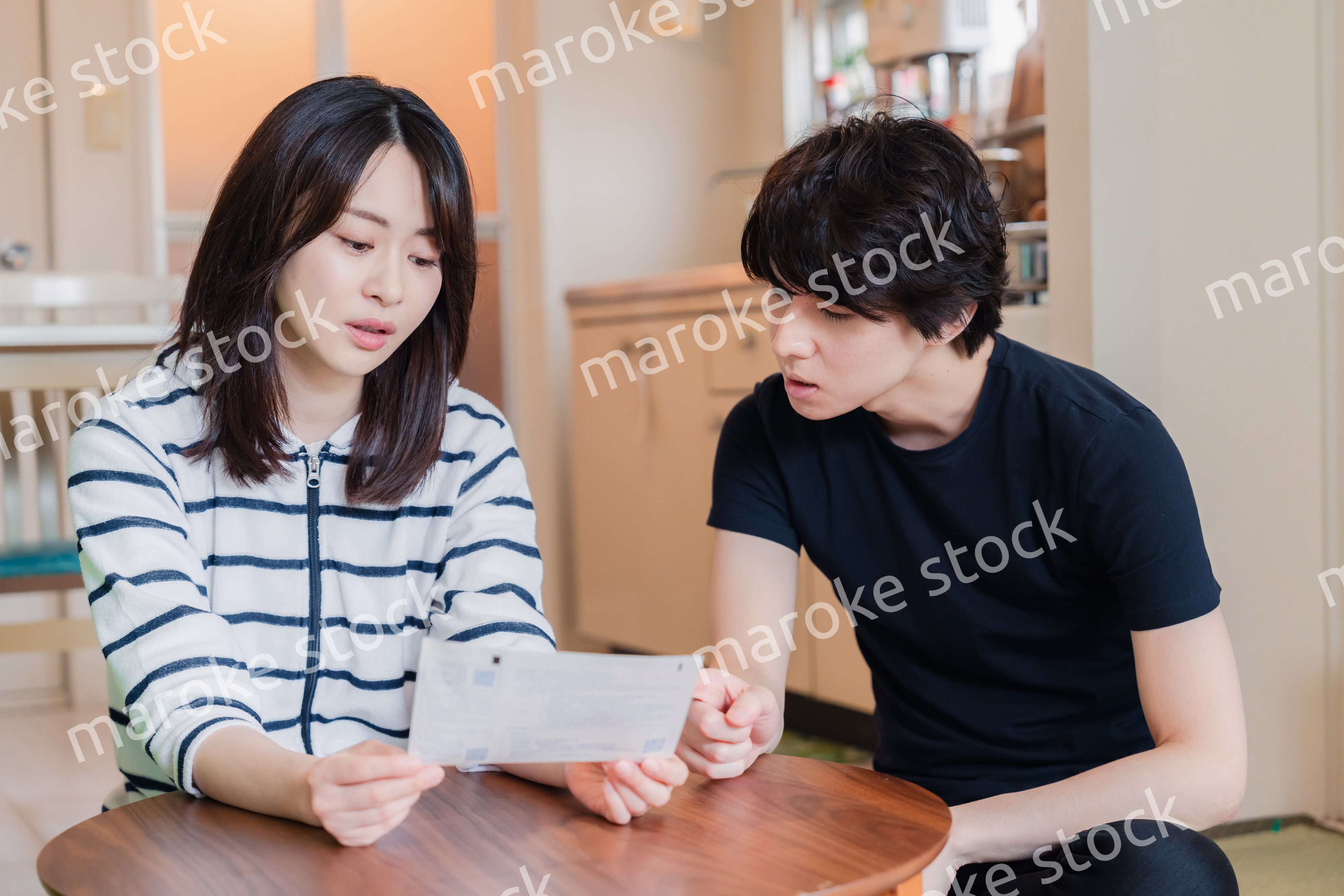 請求書明細を見て値上げに苦しむ若い夫婦