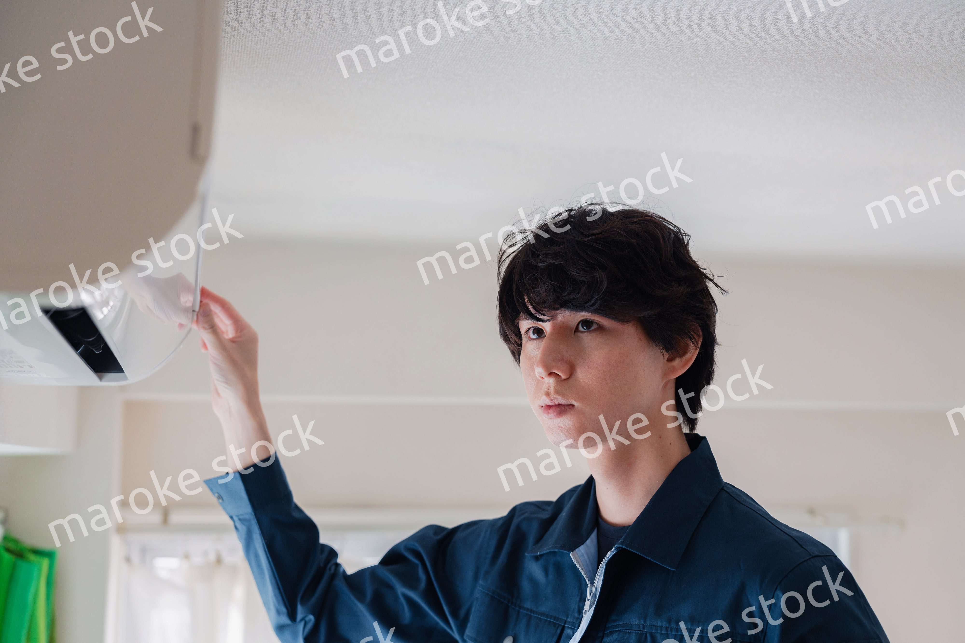 エアコンの点検をする男性