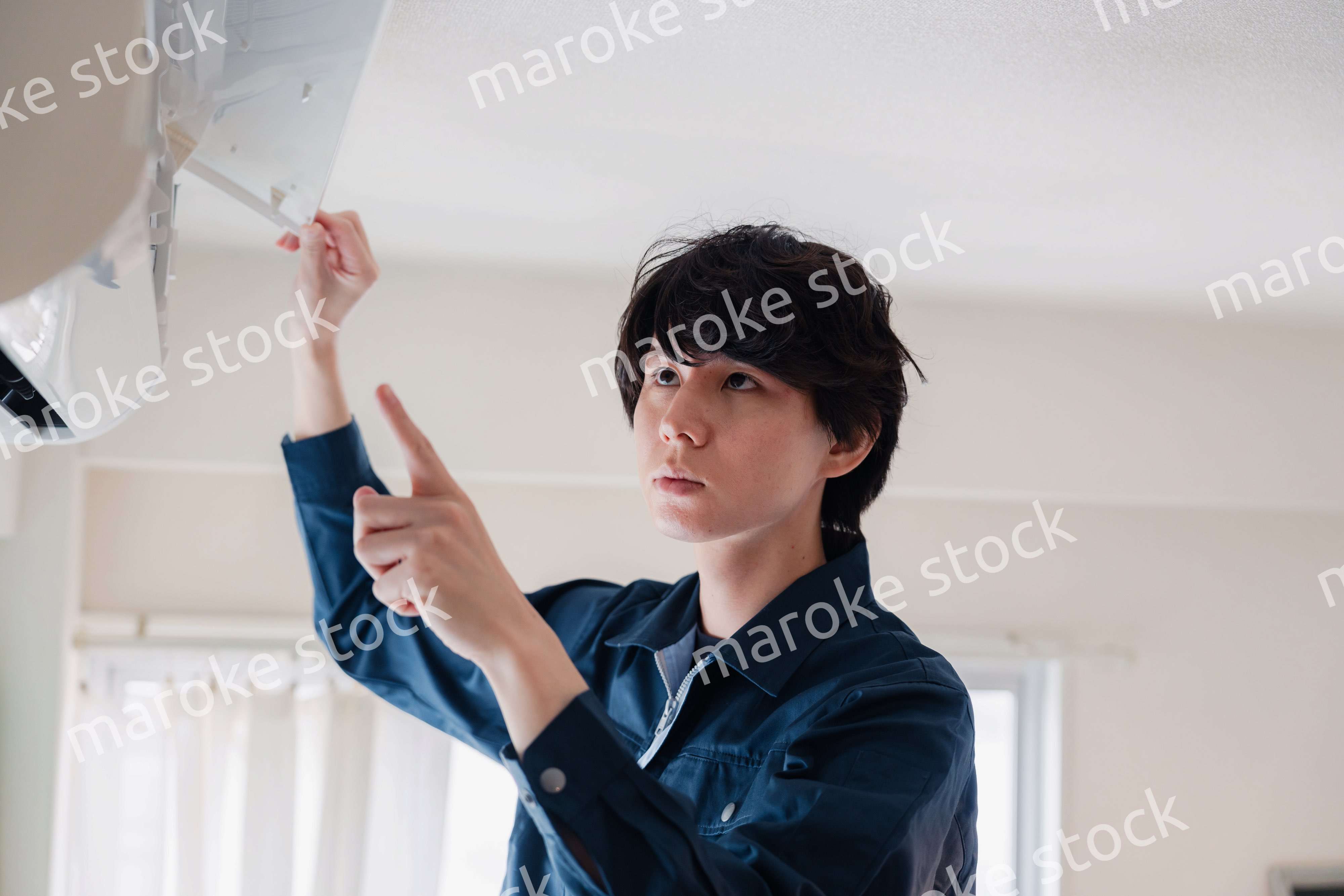 エアコンの点検をする男性