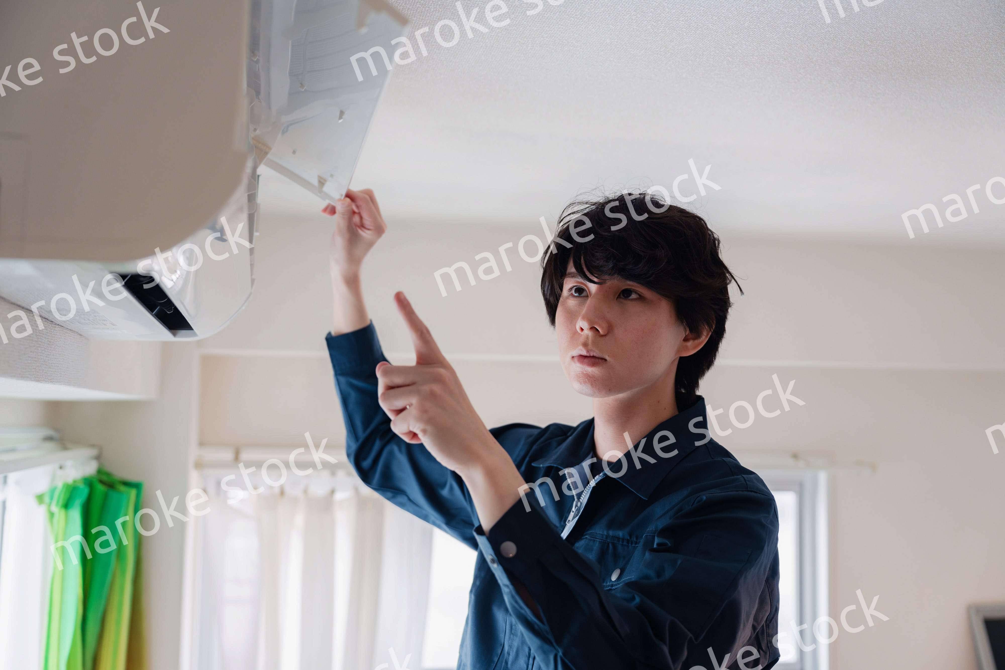 エアコンの点検をする男性