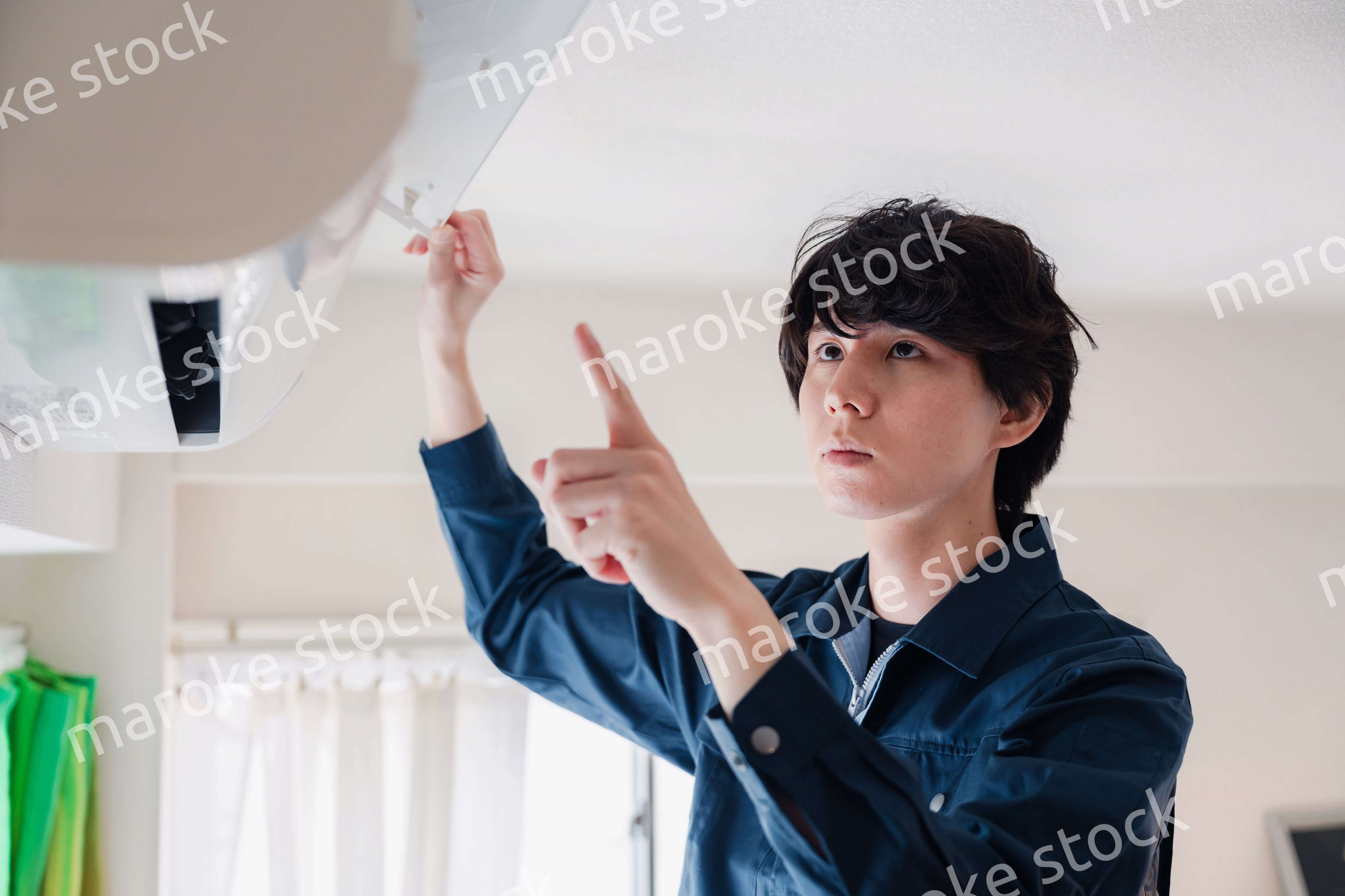 エアコンの点検をする男性