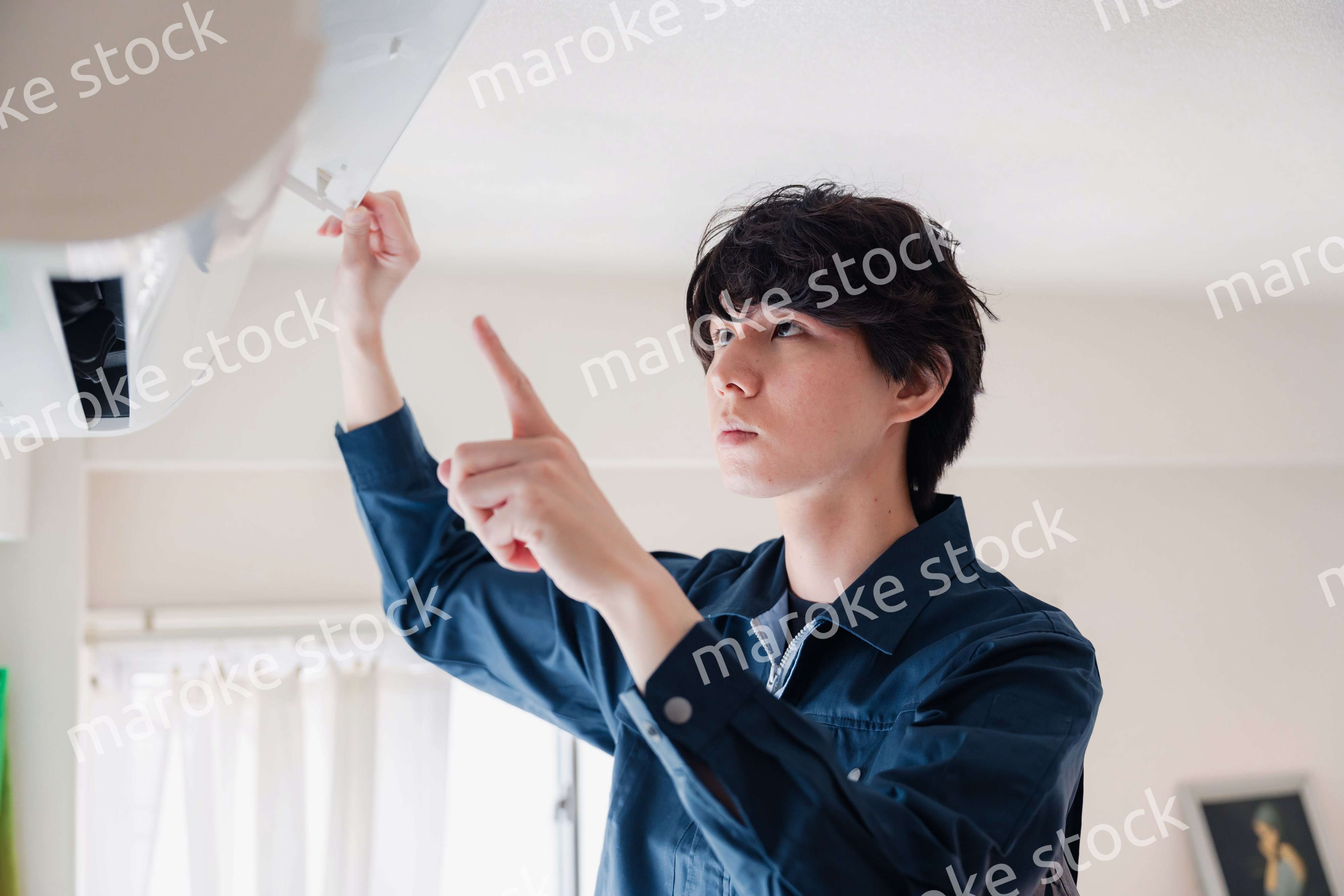 エアコンの点検をする男性