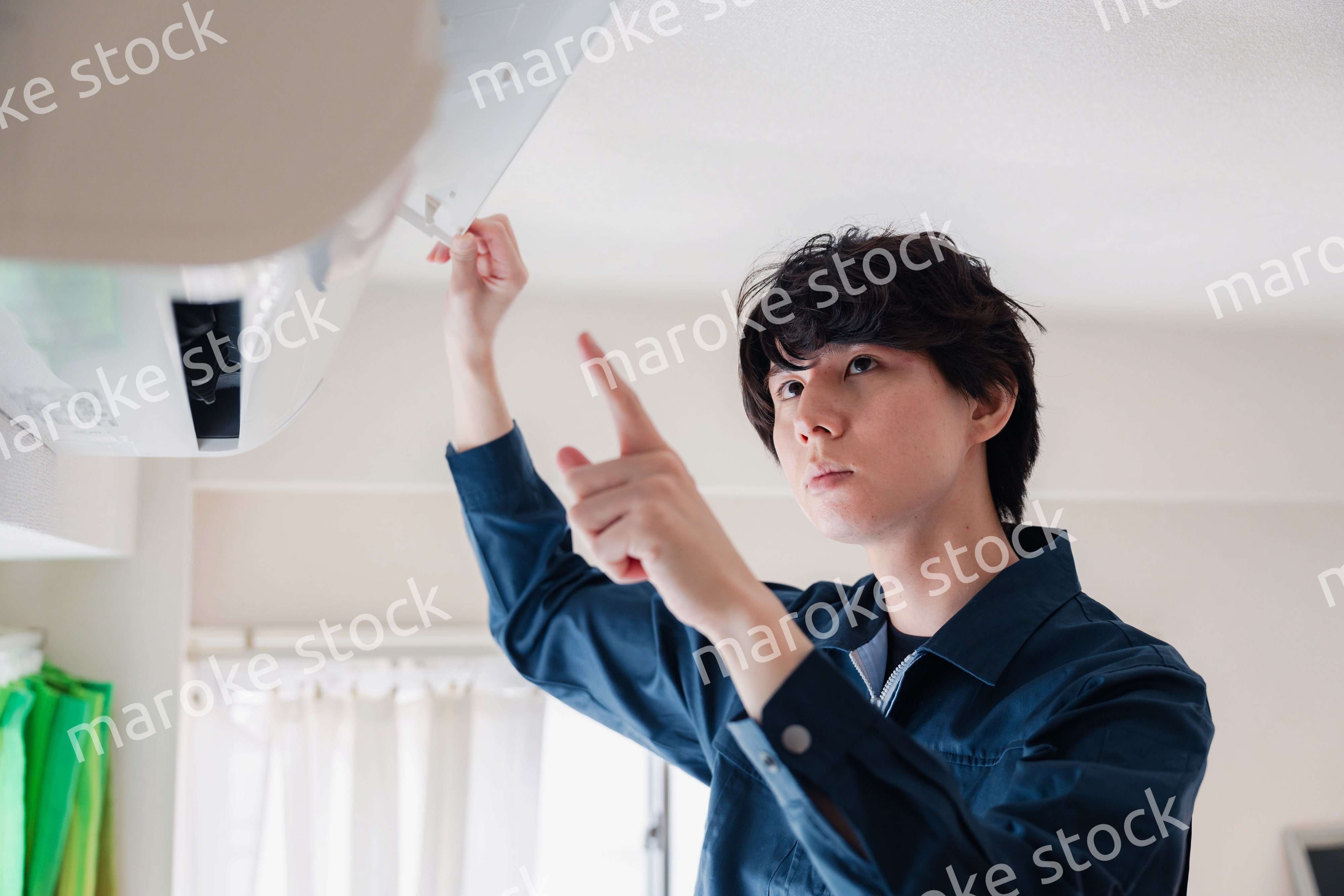 エアコンの点検をする男性