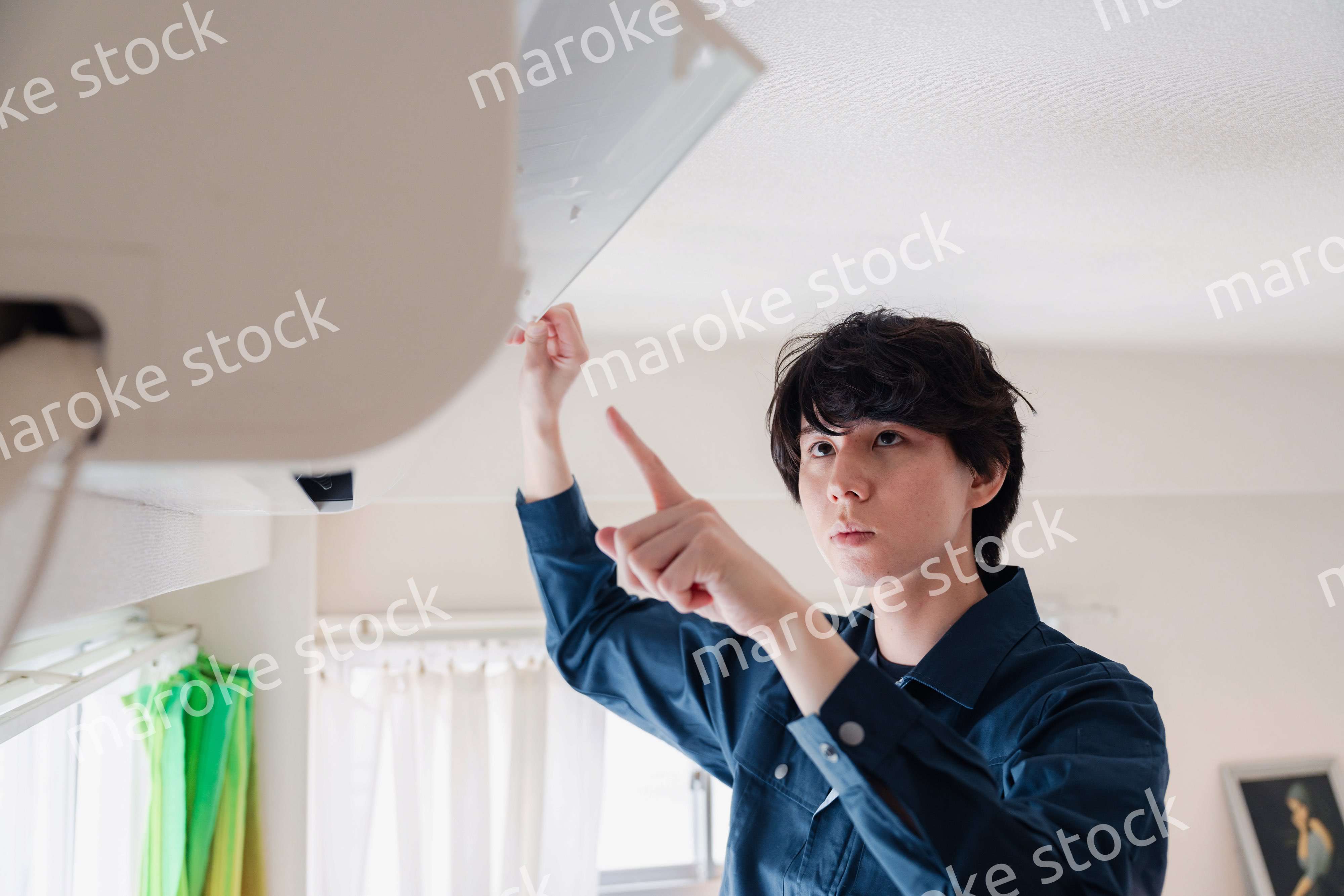 エアコンの点検をする男性