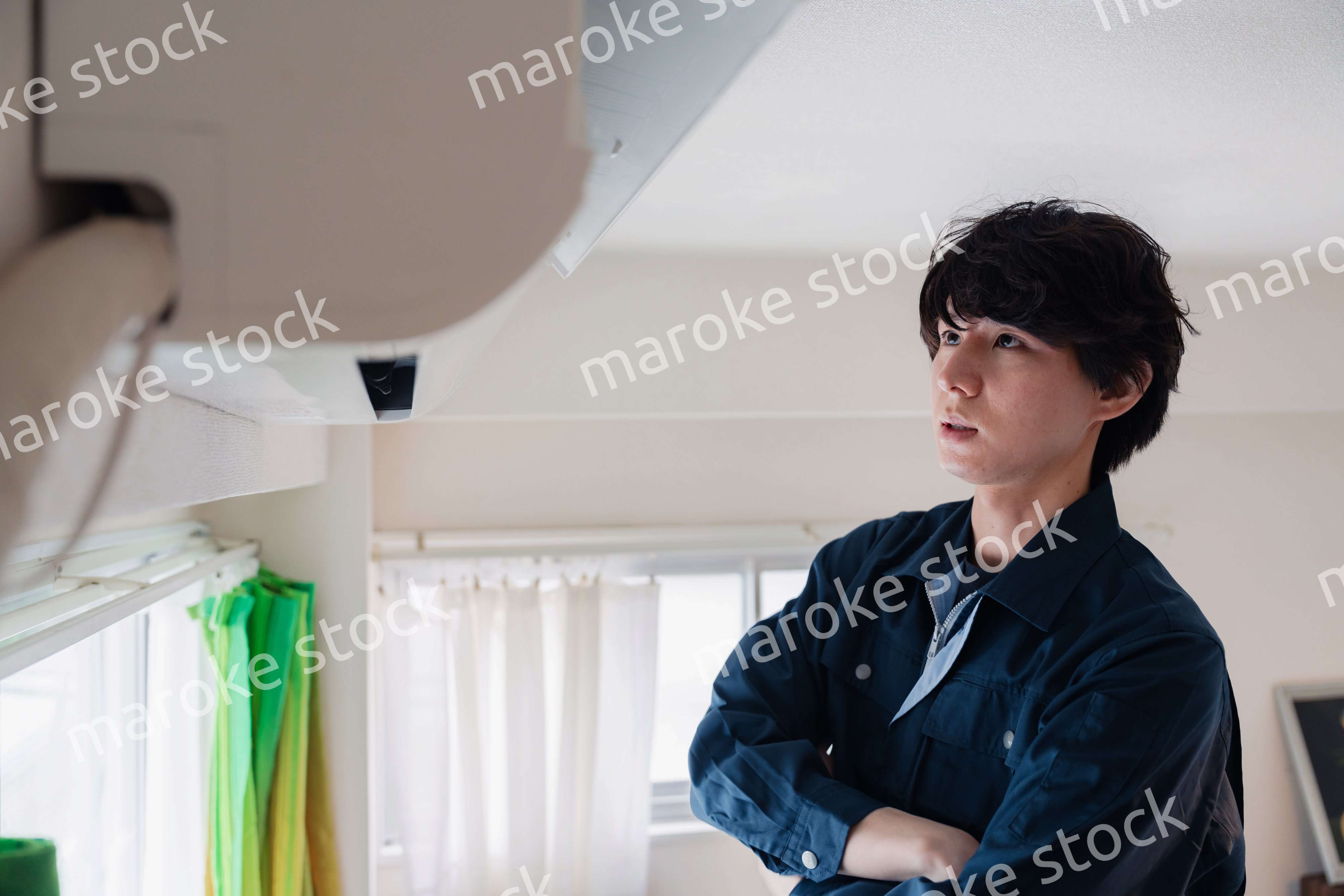 エアコンの点検をする男性
