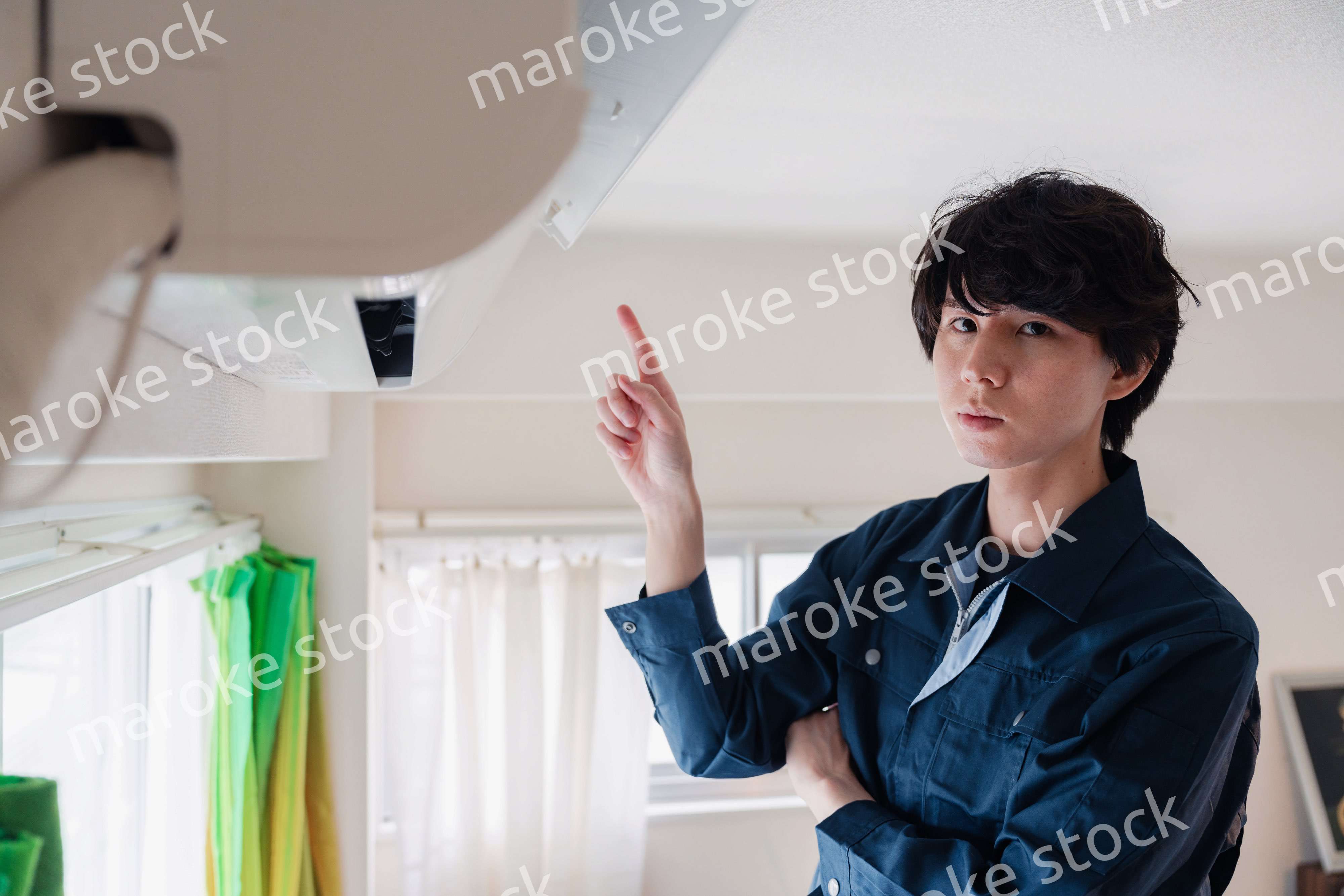 エアコンの点検をする男性