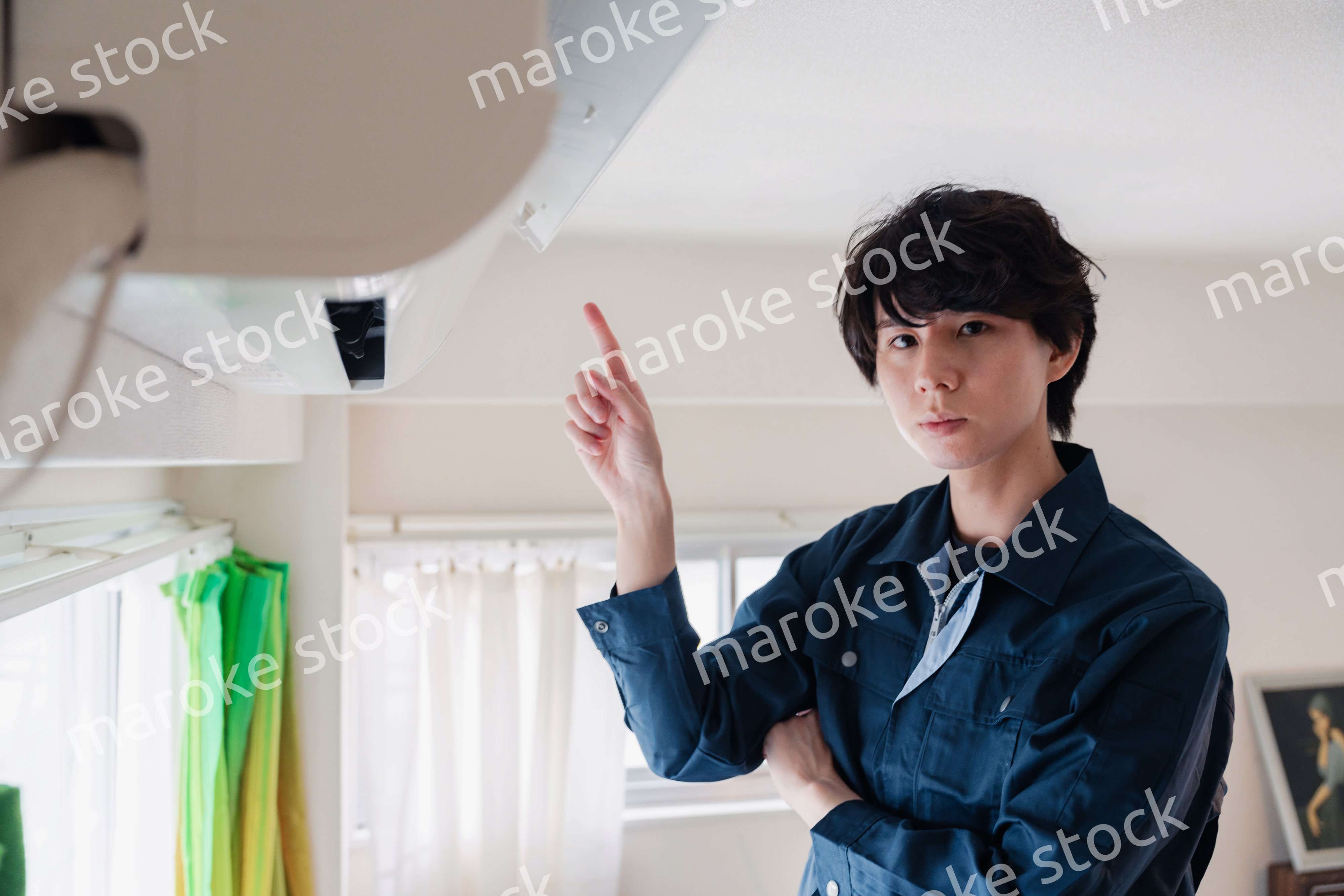 エアコンの点検をする男性