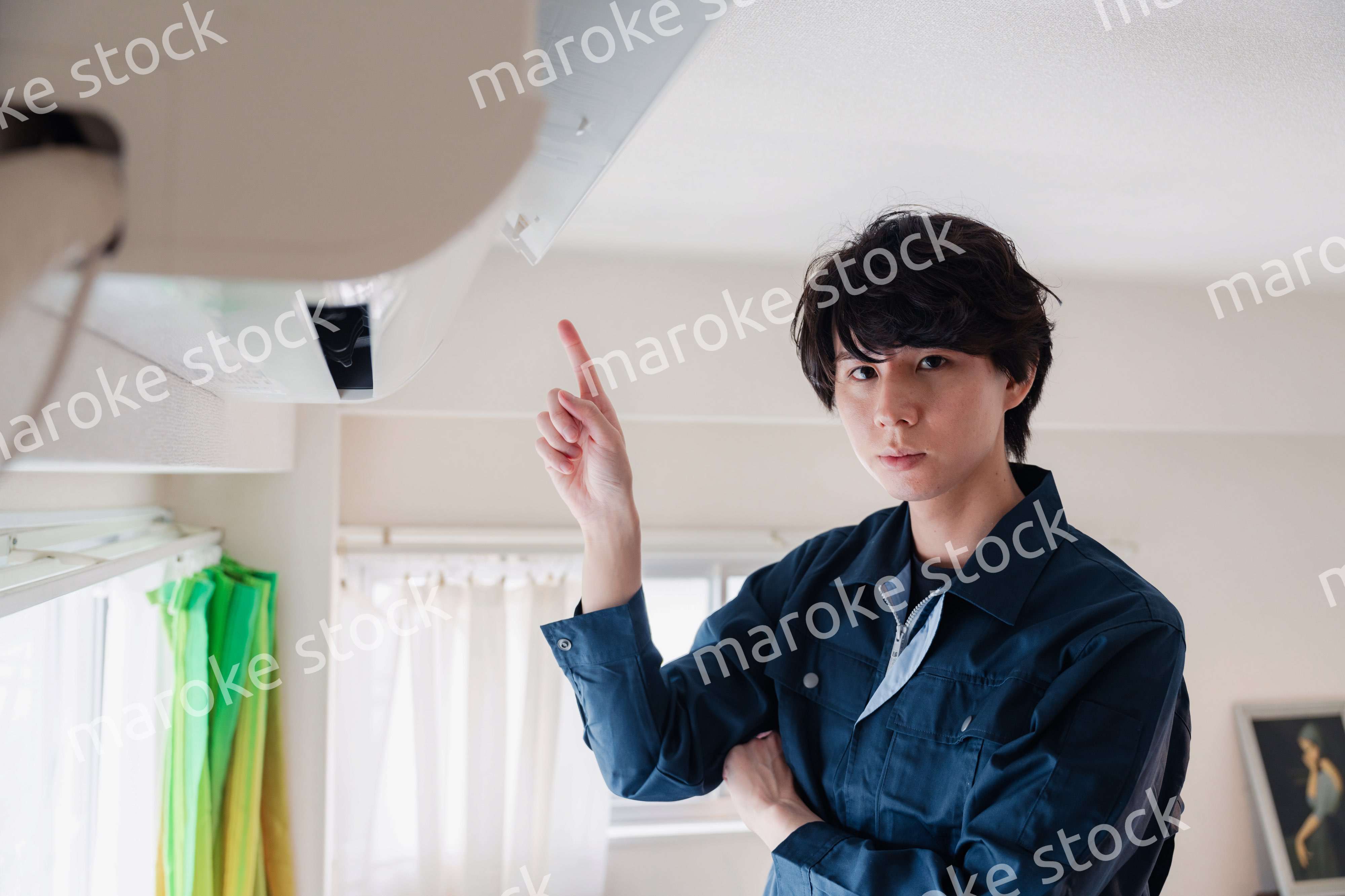 エアコンの点検をする男性
